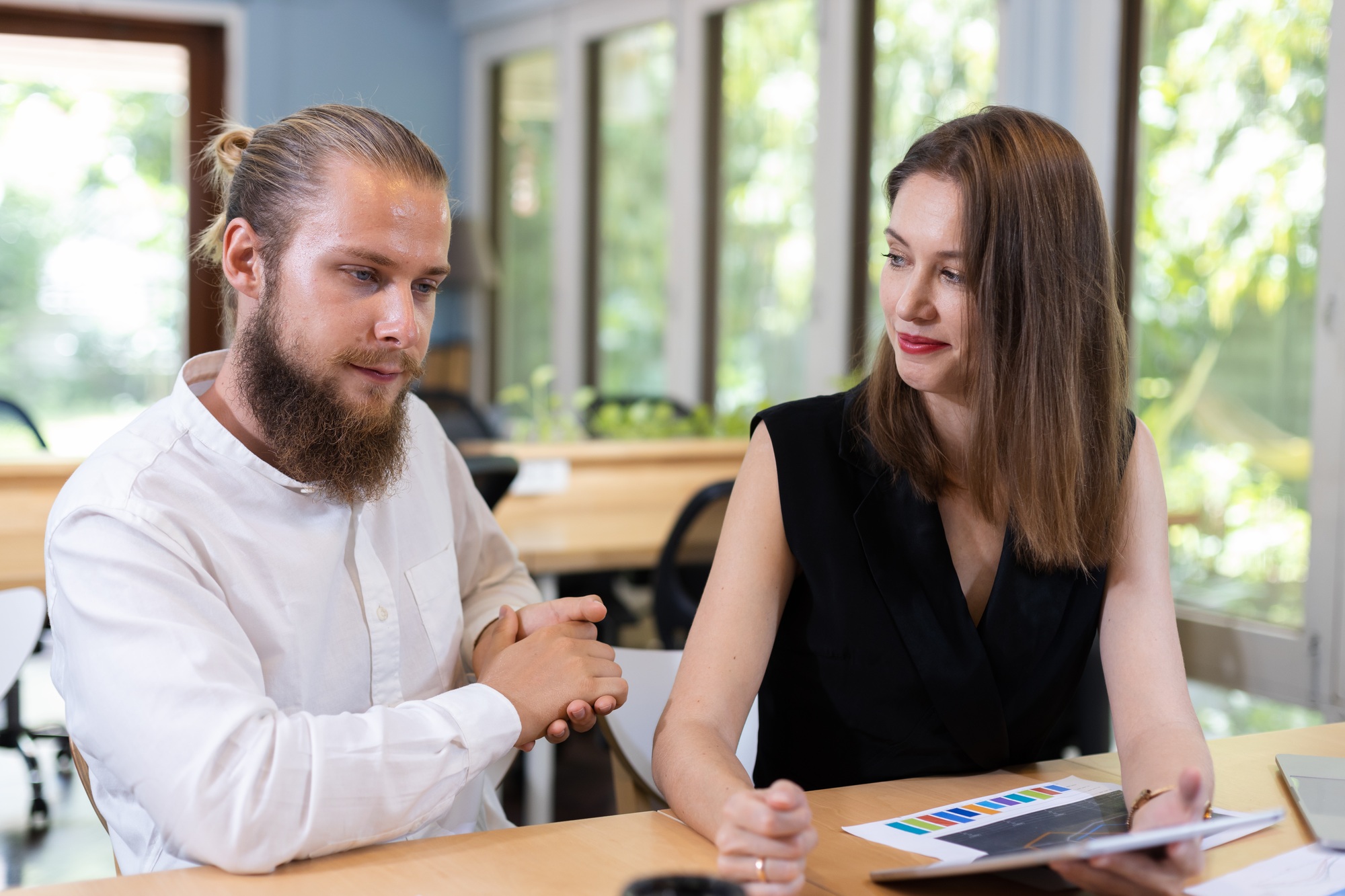 Two businesspeople talking looking document in laptop. Teamwork planning make branding.