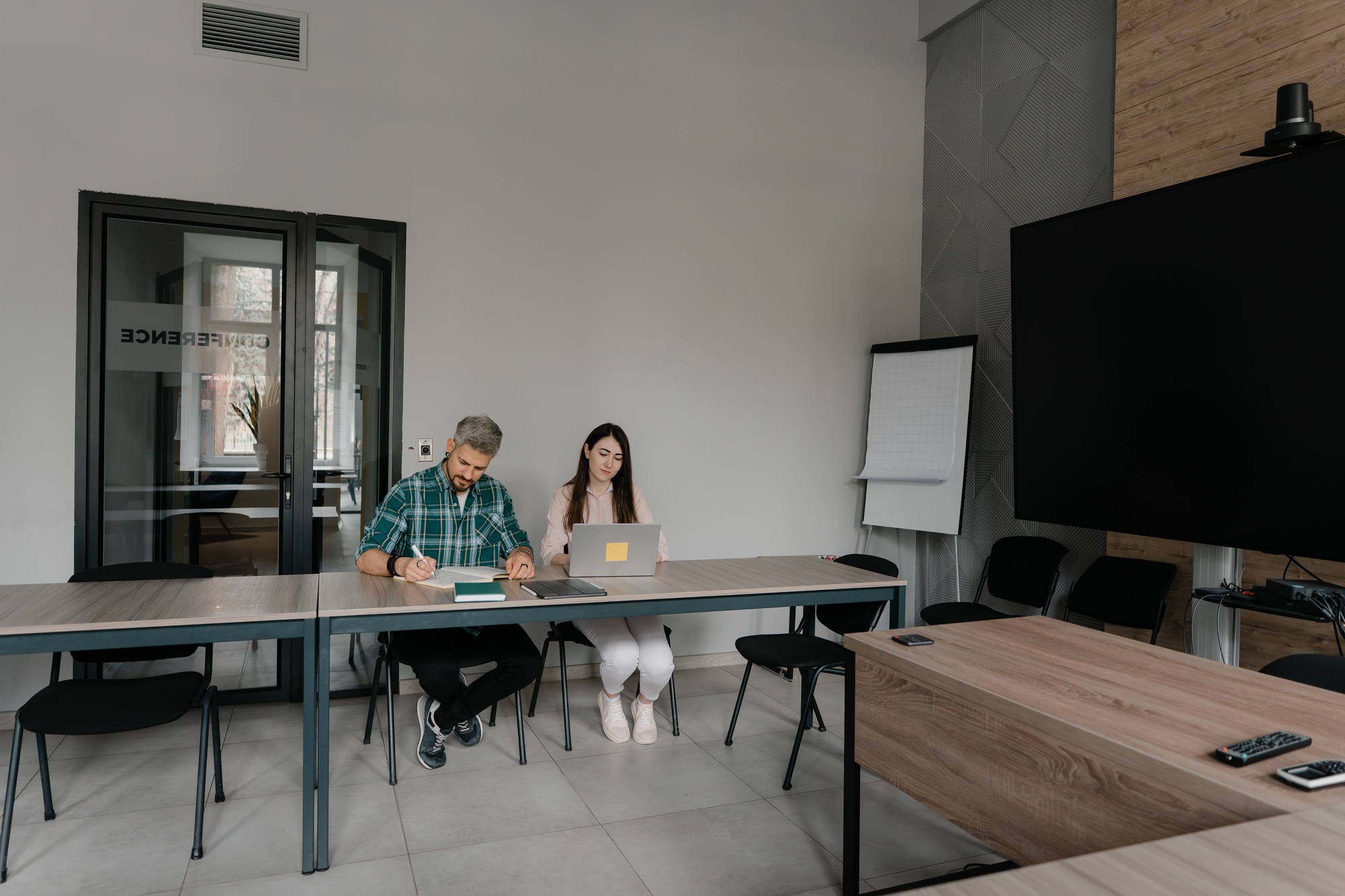 Two people working together in a modern conference room environment