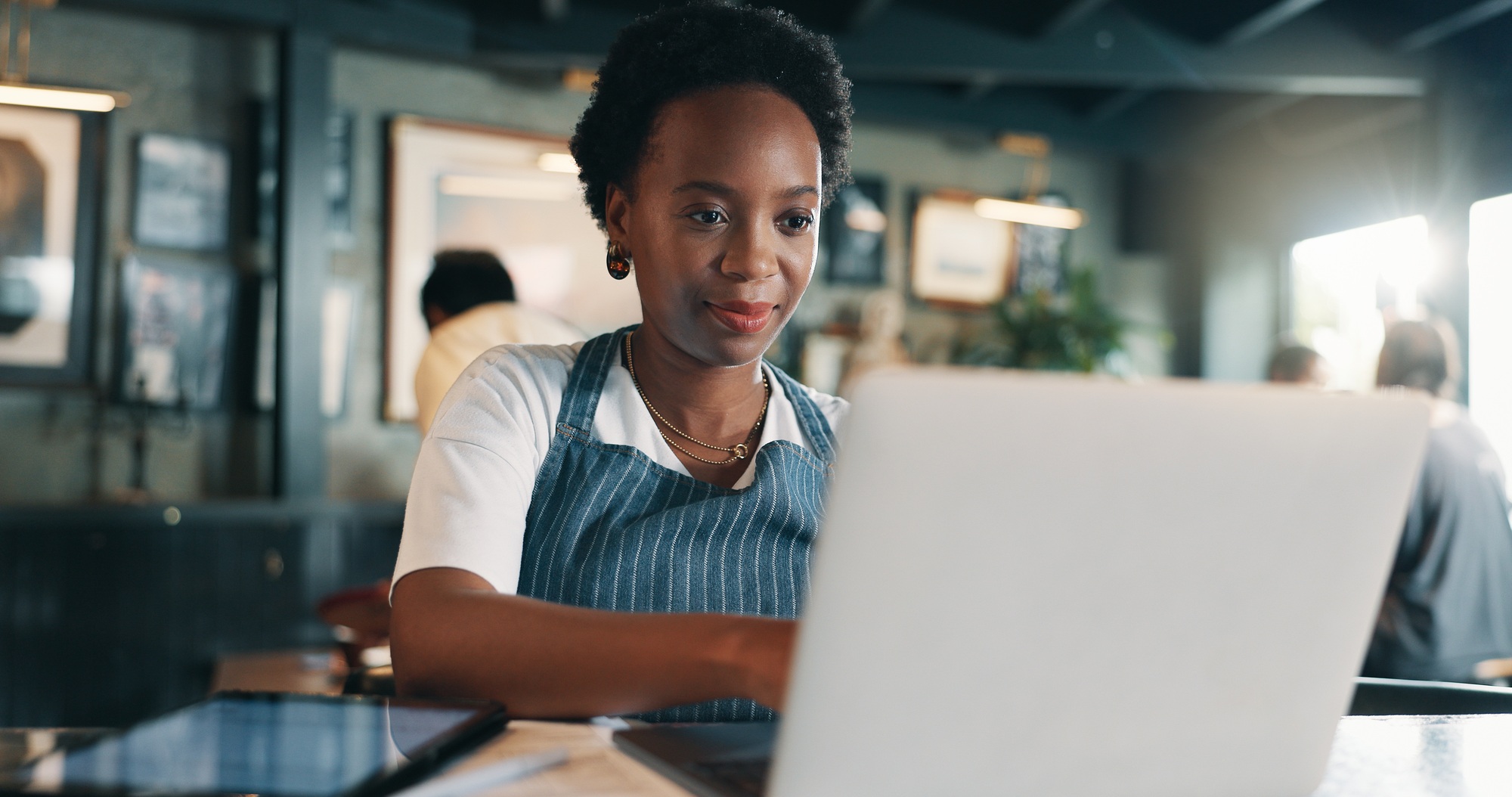Typing, laptop and planning with woman in cafe for product inventory, supplier contact or budget up