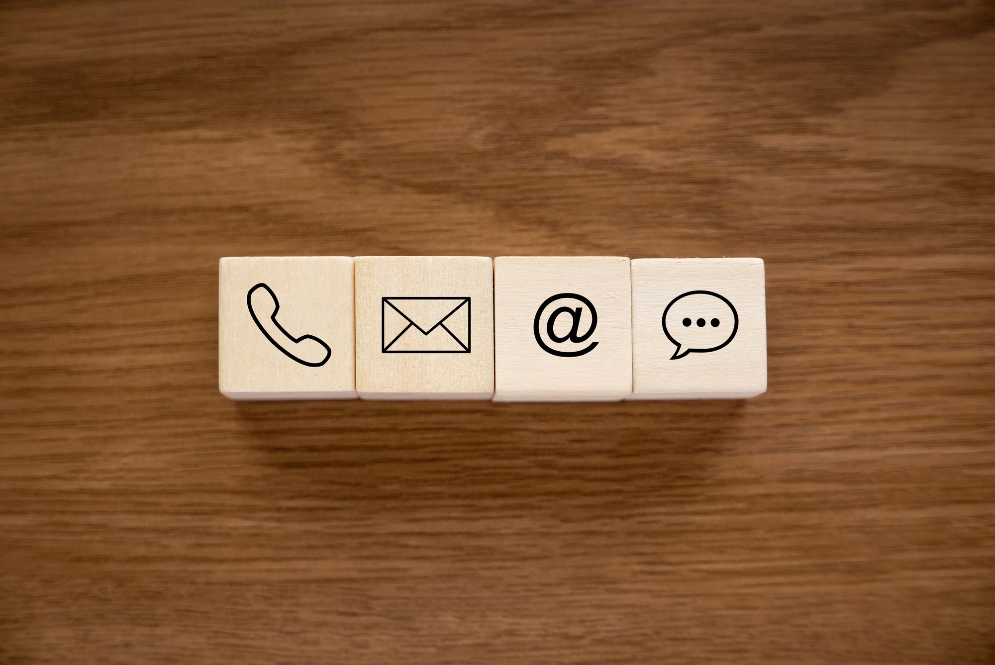 Variety of contact approach. Icon of phone, email, post and chat on a wooden cube.