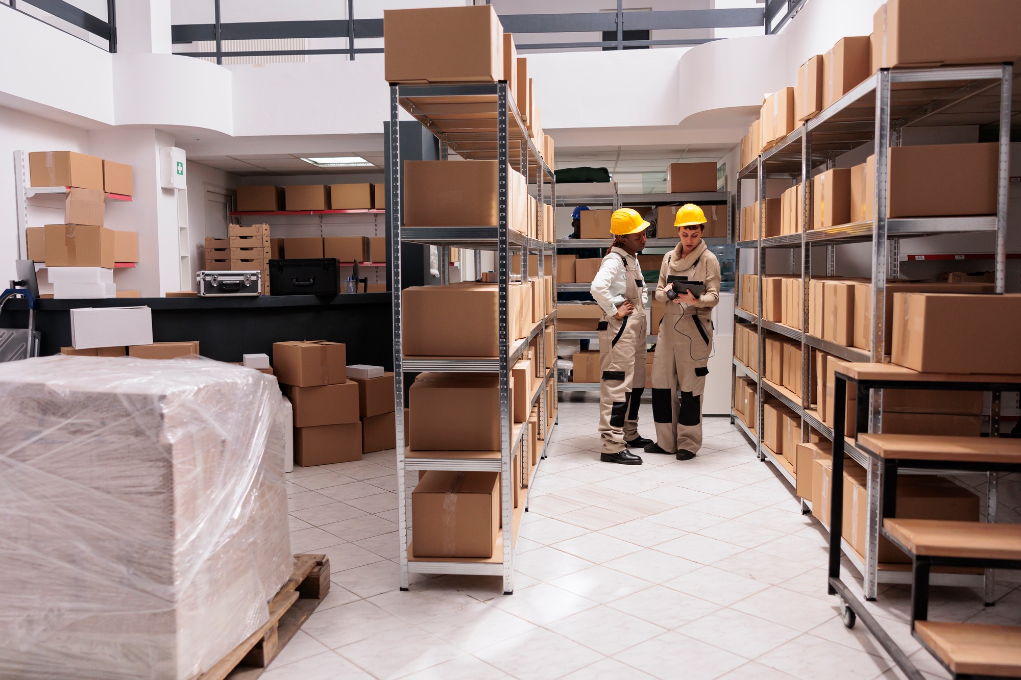 Warehouse employees scanning goods, tracking parcel in tablet software