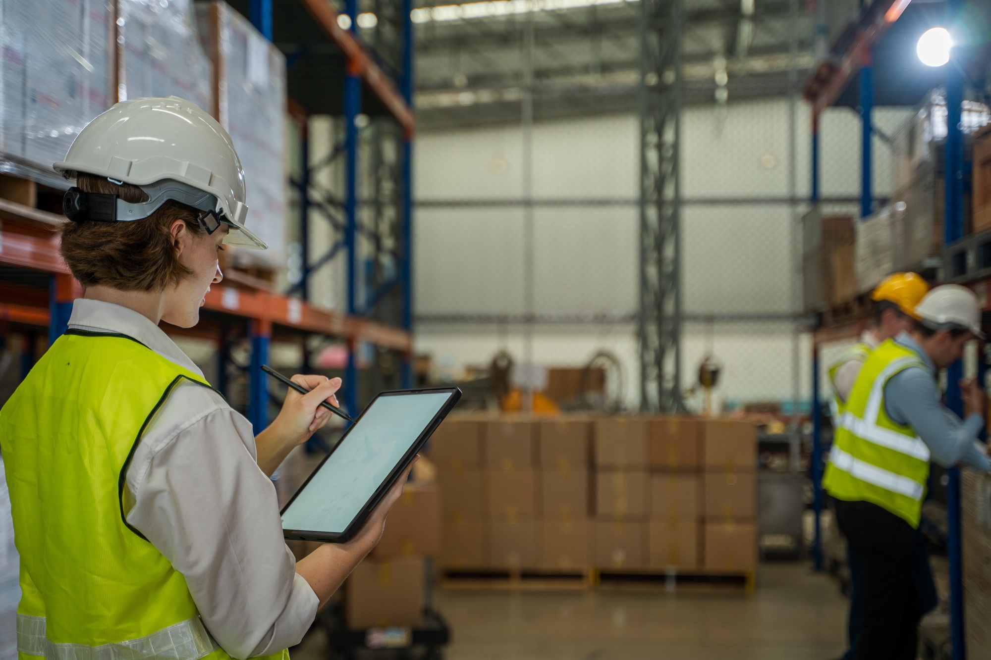 Warehouse employees uses digital tablet computer with Inventory checking software in warehouse.