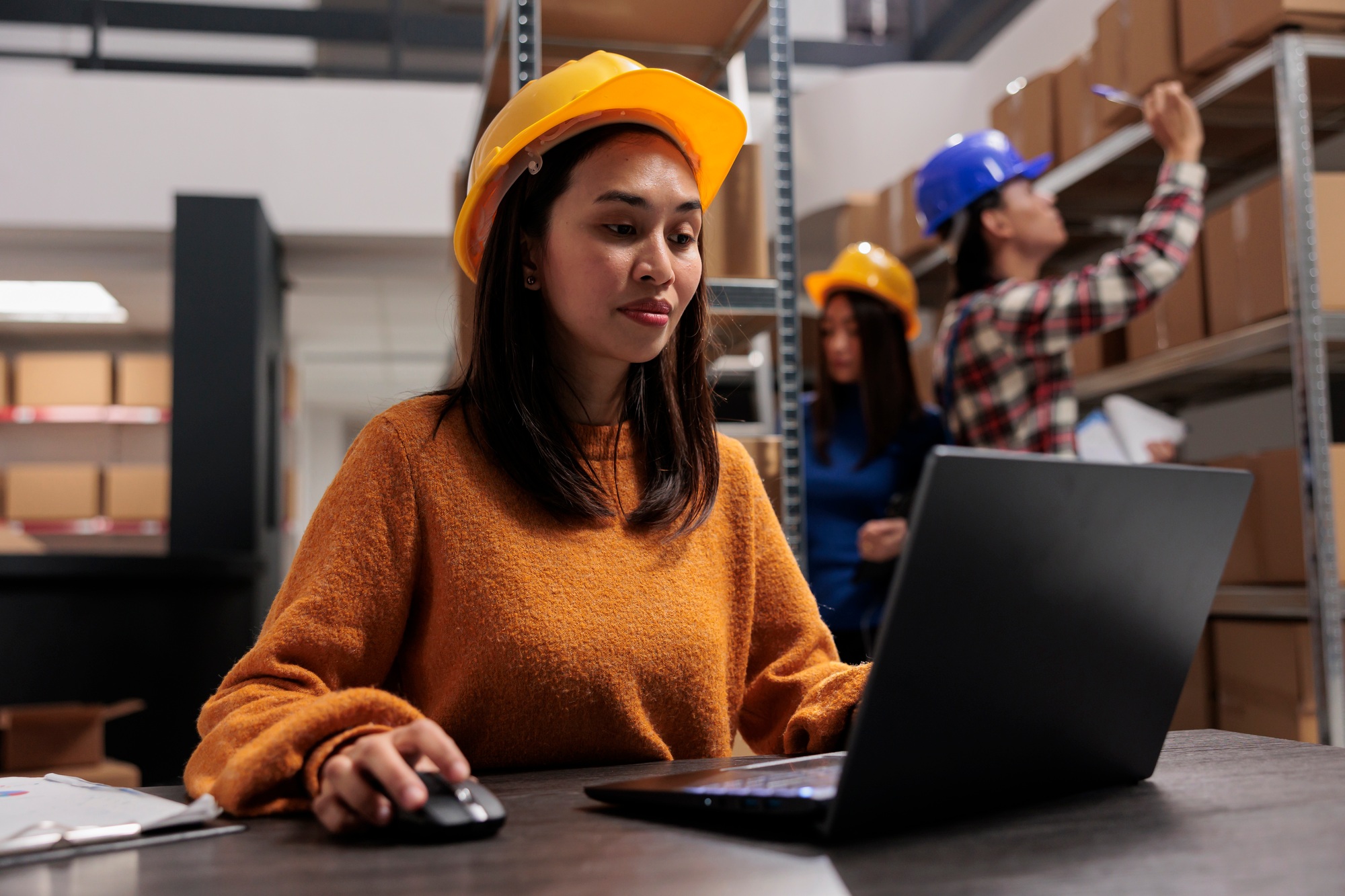Warehouse manager working on automated inventory management on laptop