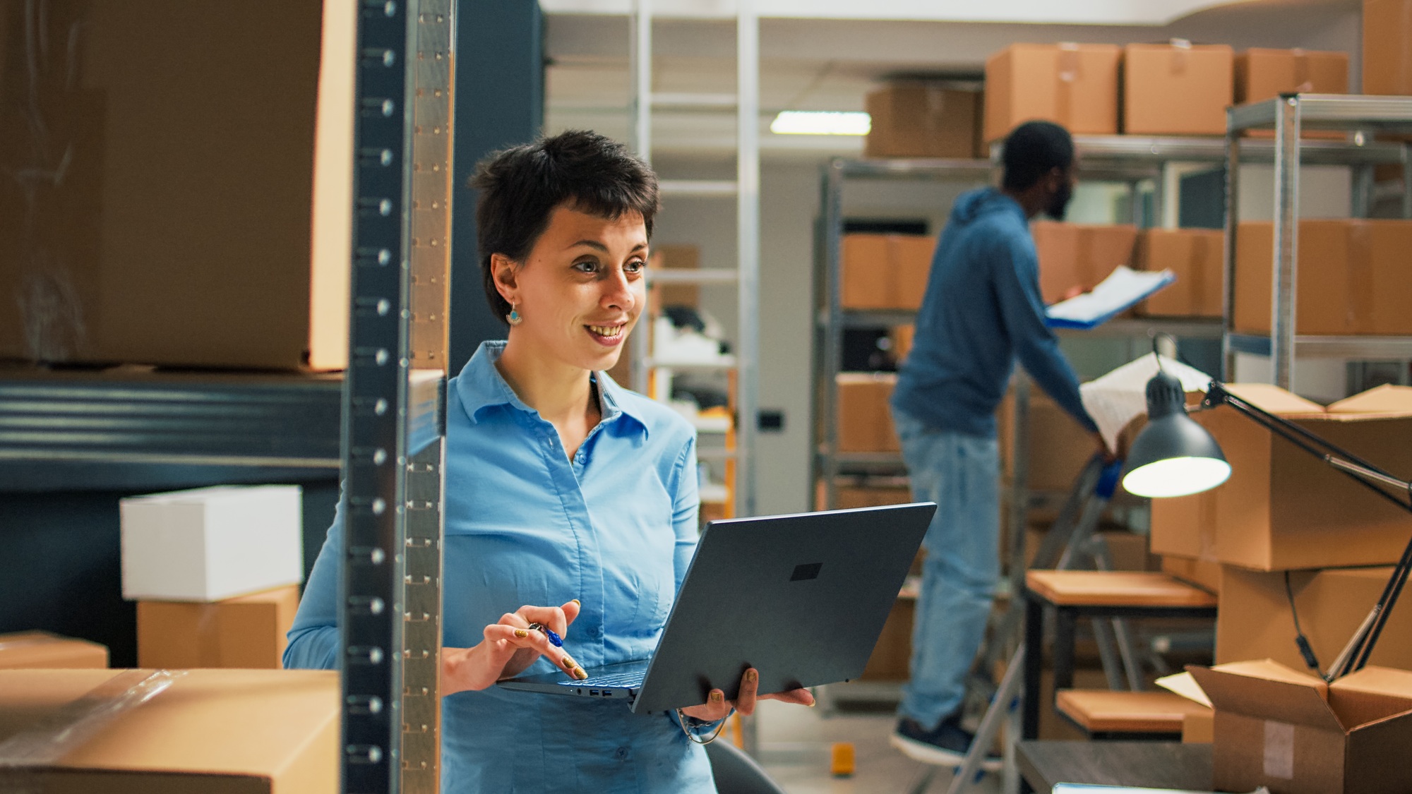 Warehouse owner checking cardboard boxes from storage space shelves
