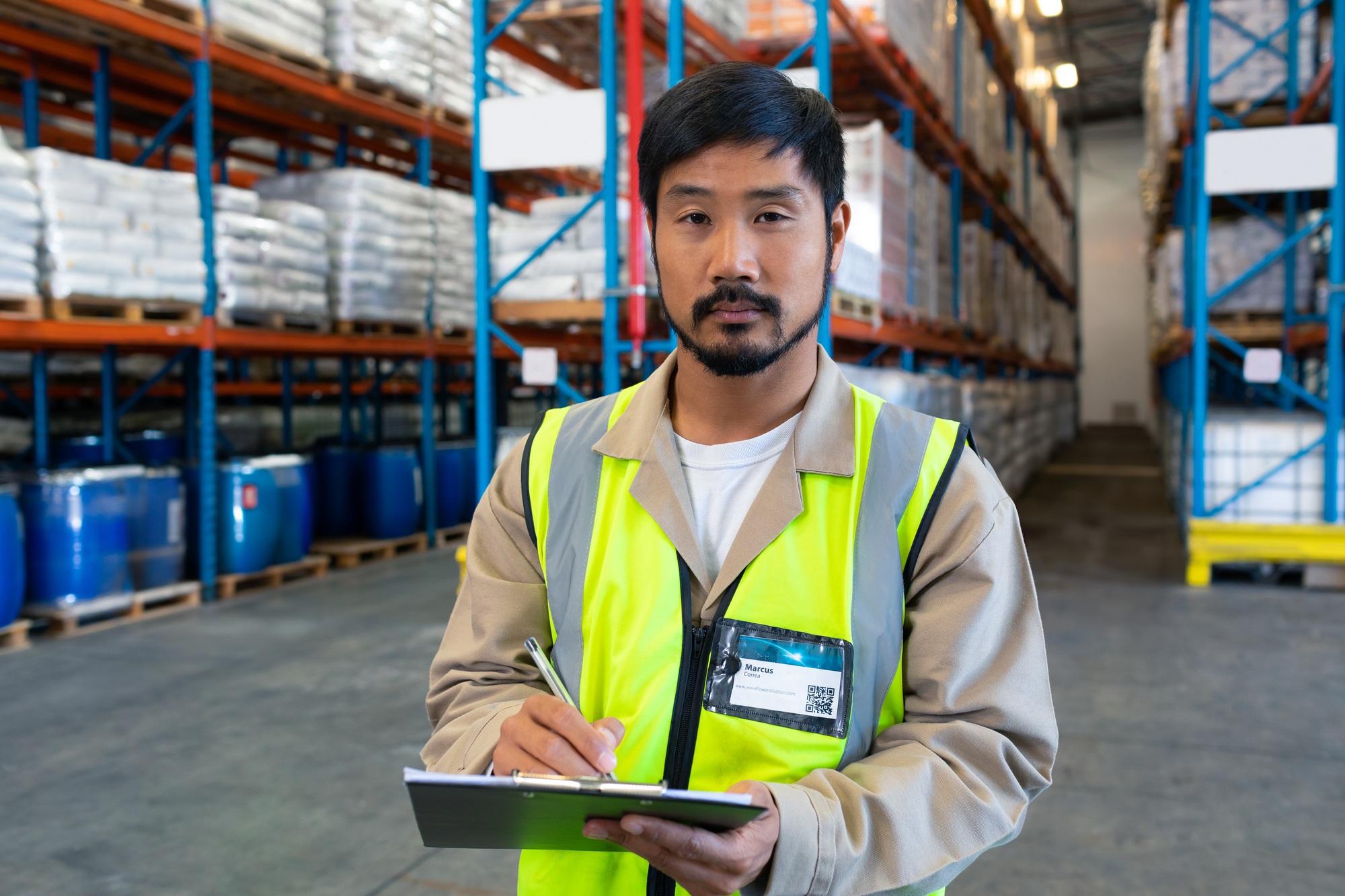Warehouse worker in safety vest checking inventory on clipboard, ensuring accuracy