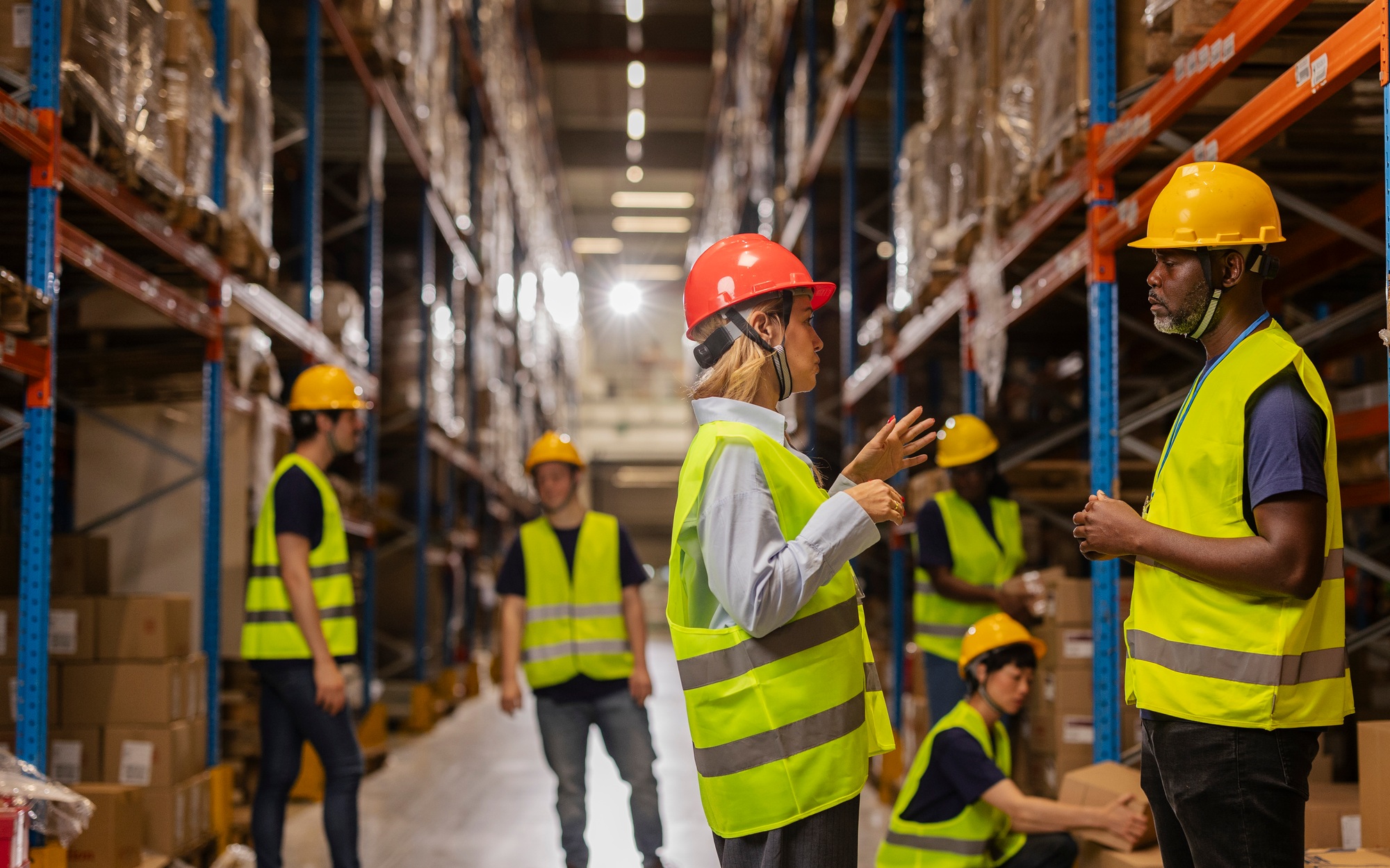 Warehouse workers and manager discussing logistics and inventory management