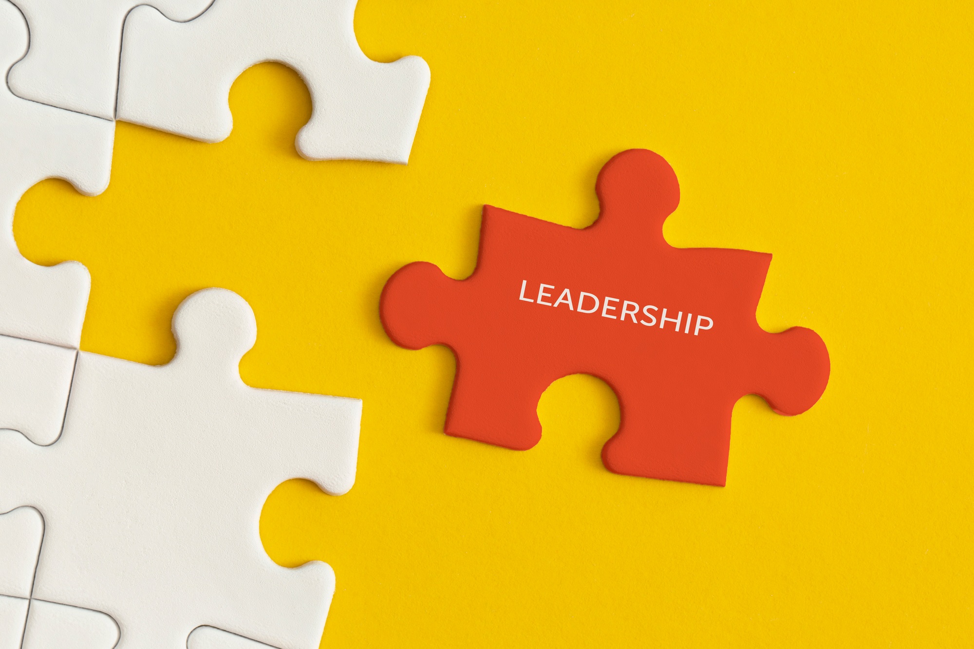 White details of puzzle on yellow background. Business strategy, teamwork, leadership.