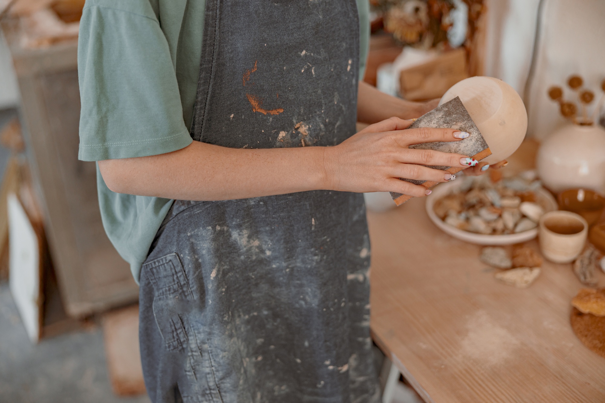 Woman ceramist making clay craft for sale in workroom