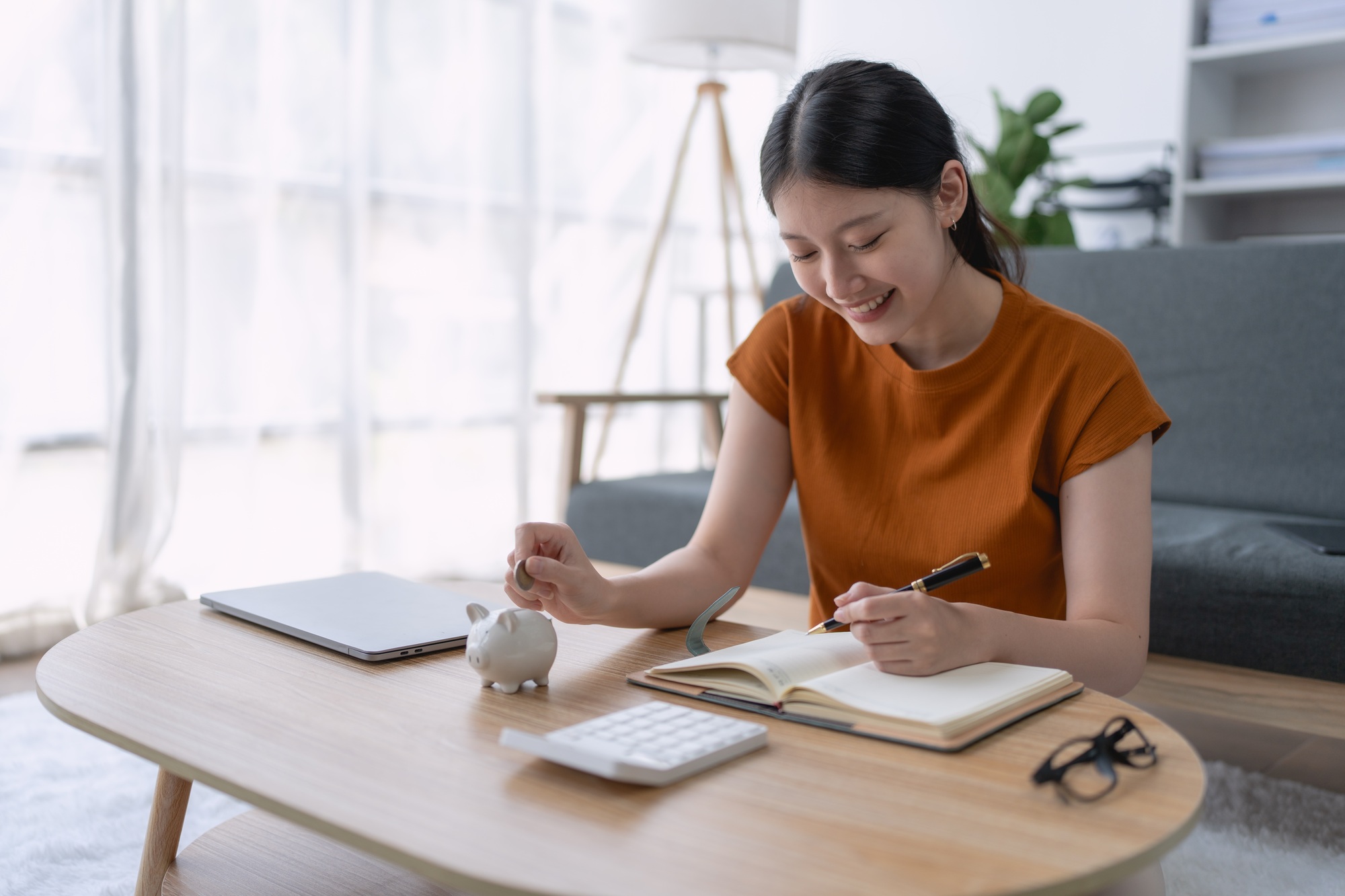 woman financial saving plan in a notebook, organizing her goals and budgeting strategies to achieve