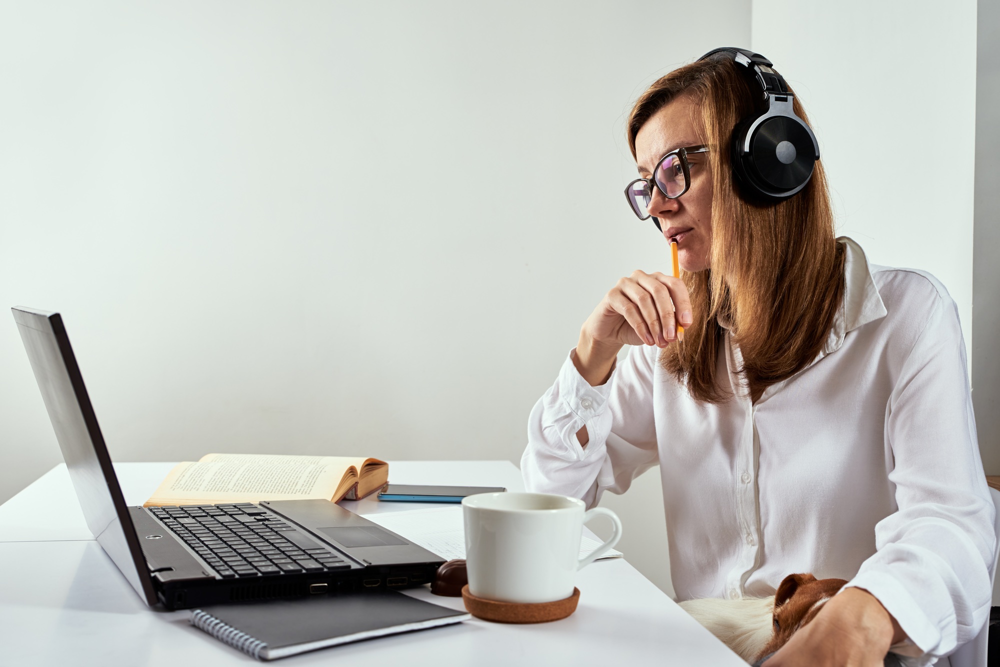 Woman in headphones listen audio course at laptop