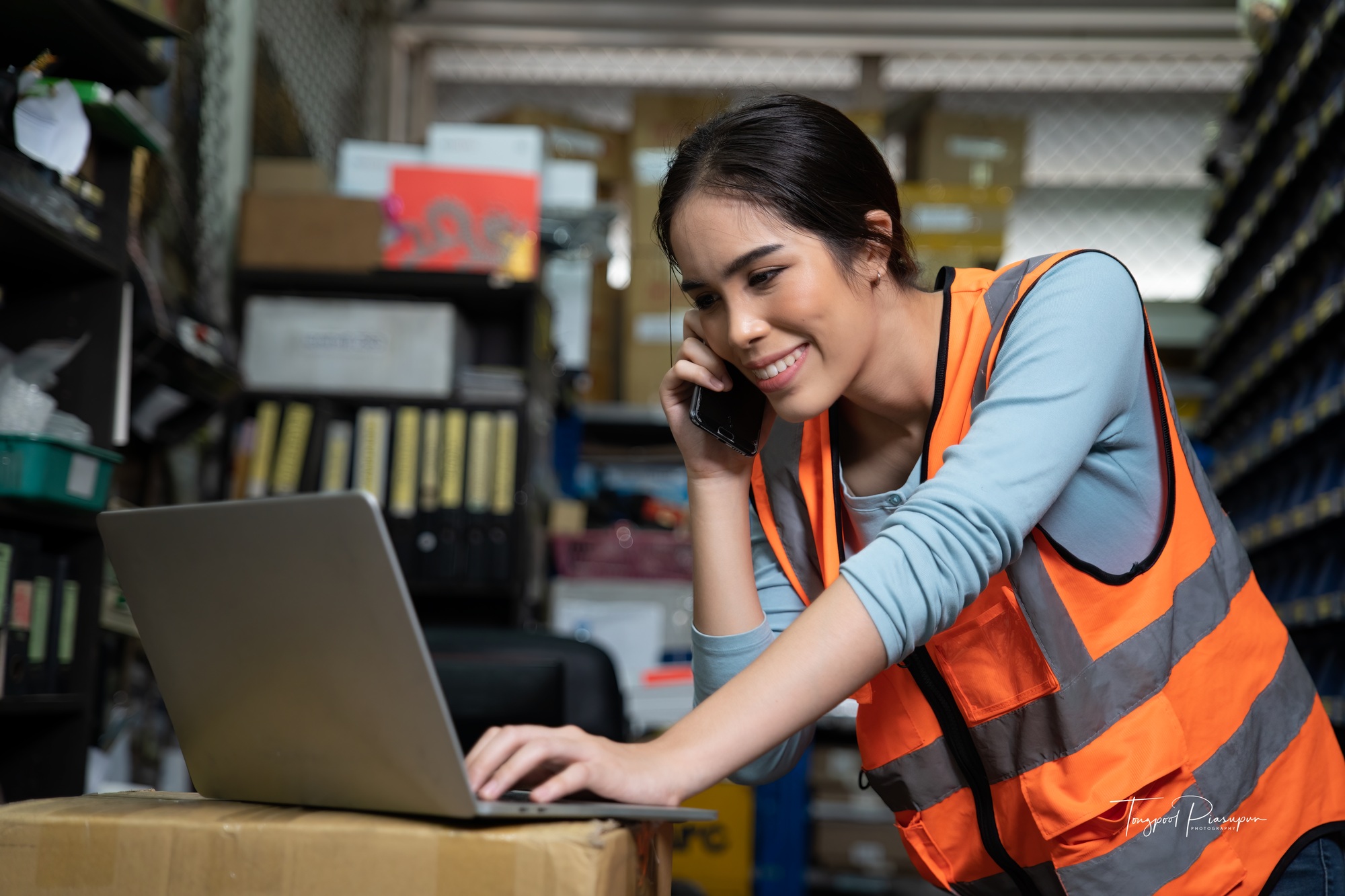 woman in storage room working at office inventory checking available stock in laptop computer
