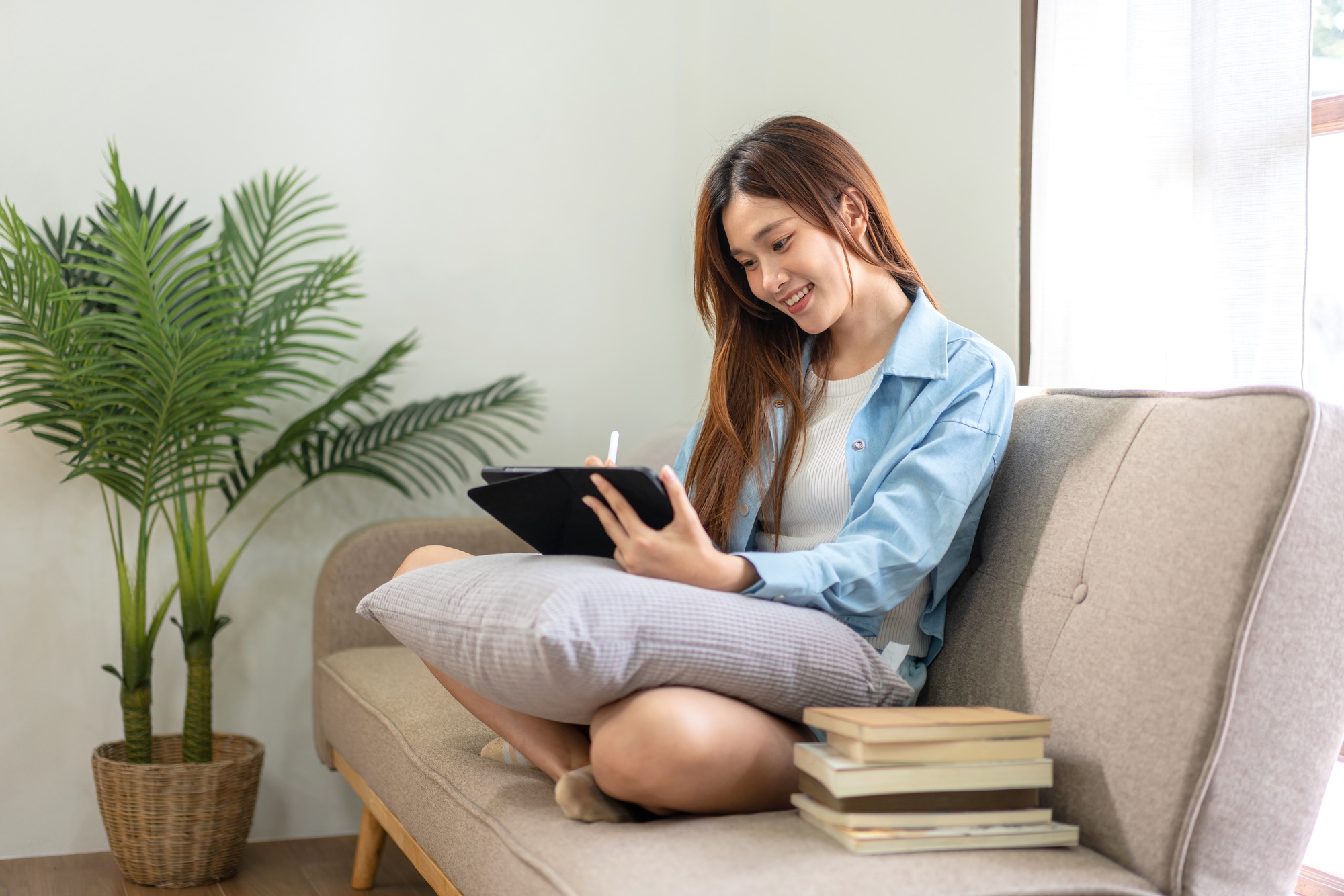 woman is analyzing strategy goal of business and taking notes on tablet while working on comfortable