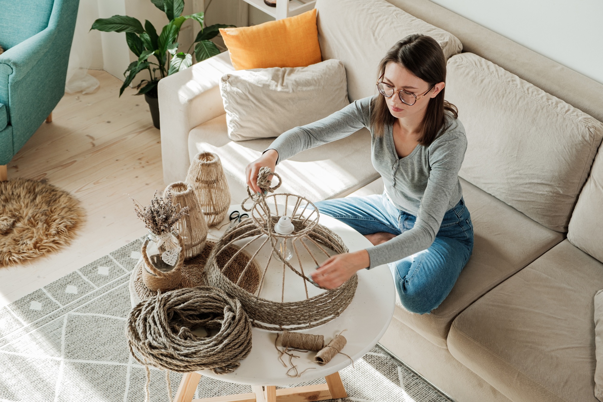 Woman makes handmade diy lamp from jute rope