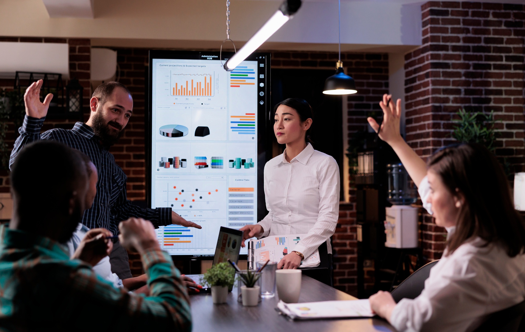 Woman raising hand to ask a question in late night business meeting with sales department