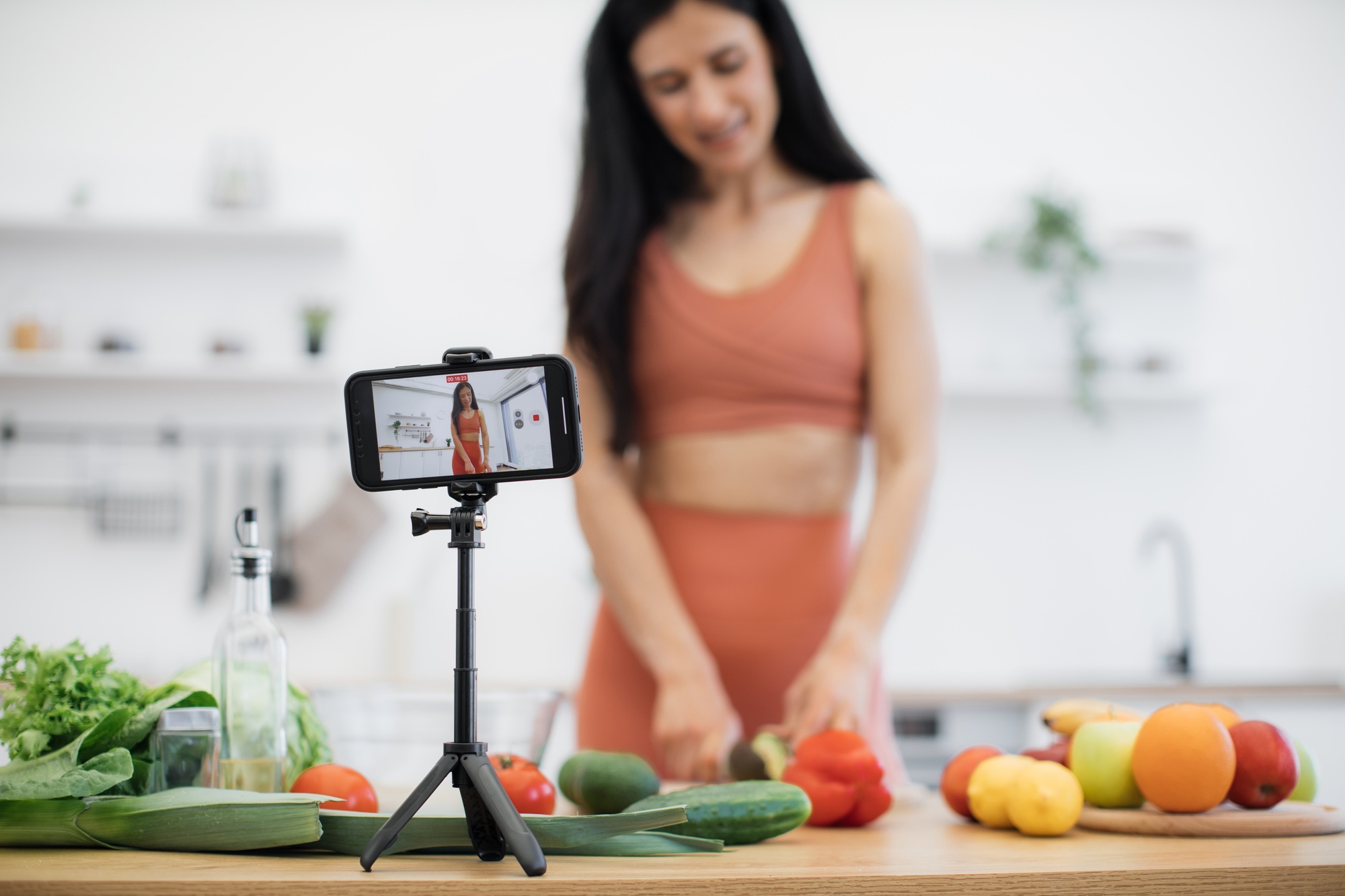 Woman sharing eating tips online while peeling fruit at home