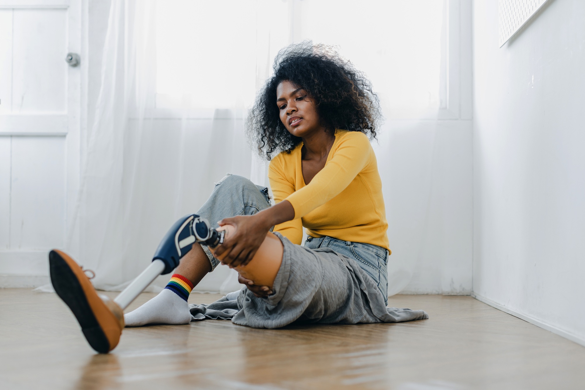 Woman with prosthetic leg doing physical therapy exercise at home.