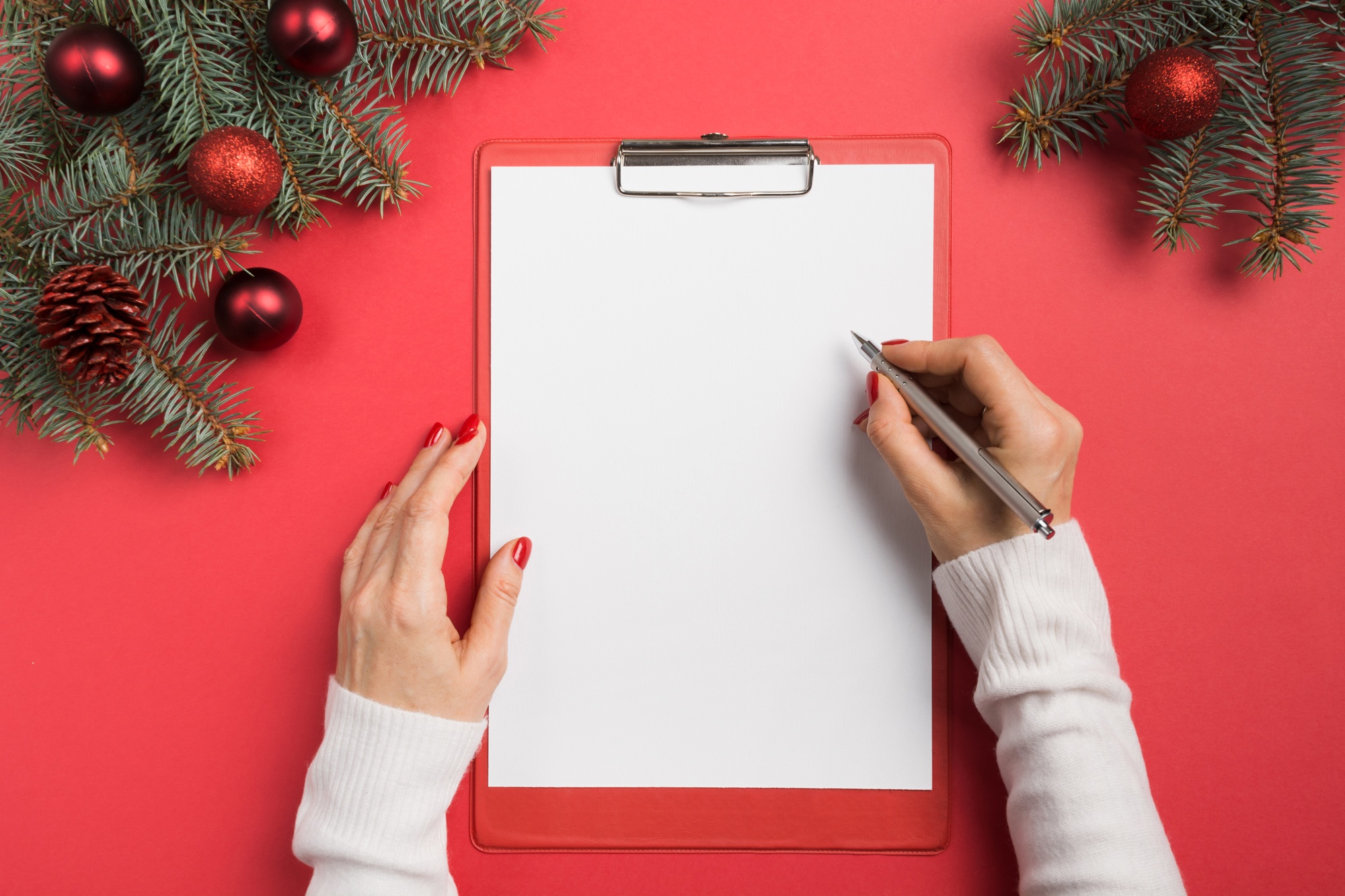 Woman writes goals, checklist, plans and dreams for New Year.