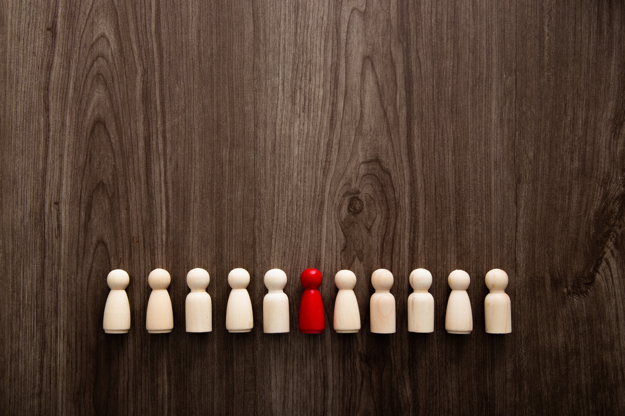 Wooden people figures on wooden background. Career growth, development and leadership