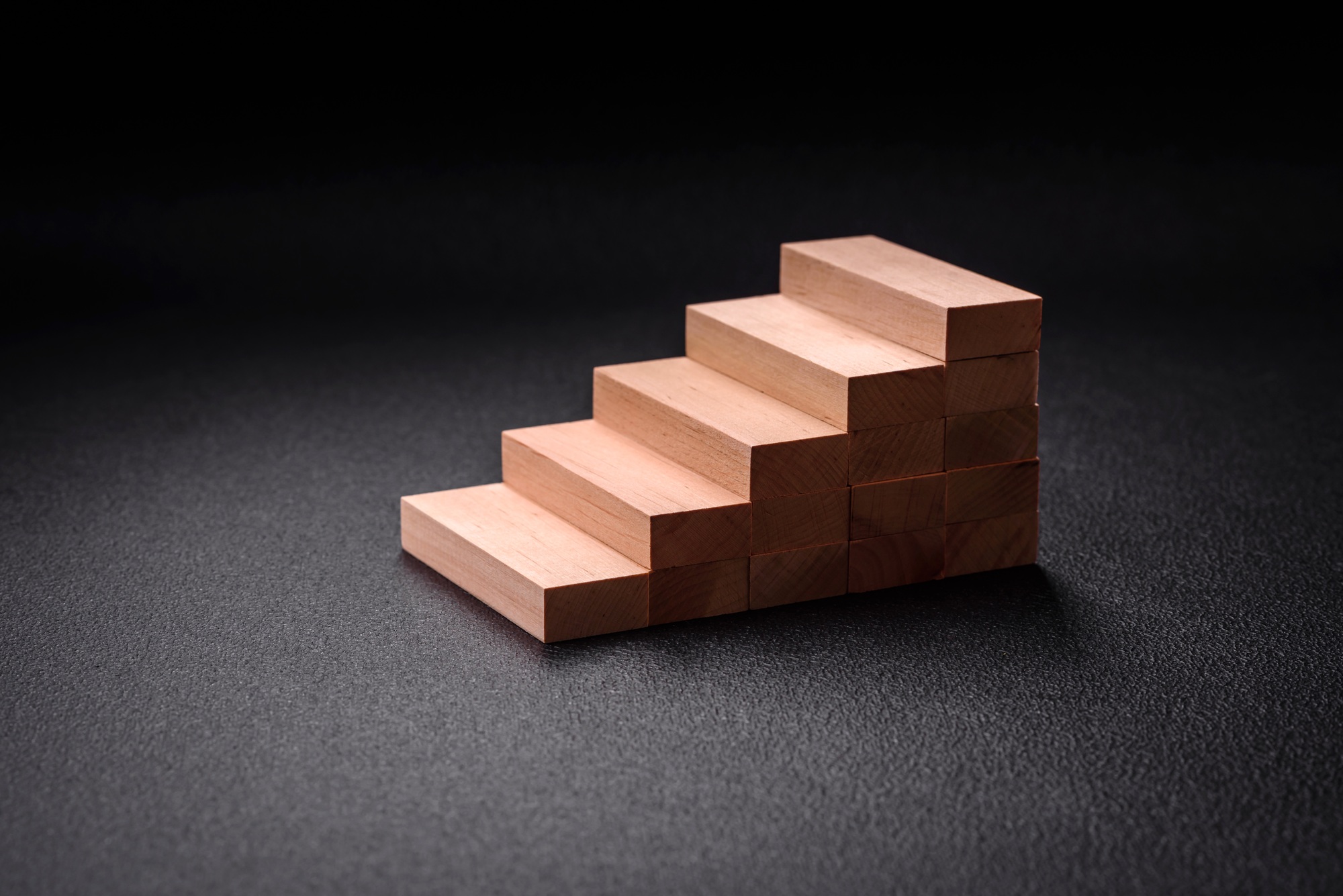 Wooden steps made of blocks as an idea of investment and profit growth in achieving a goal