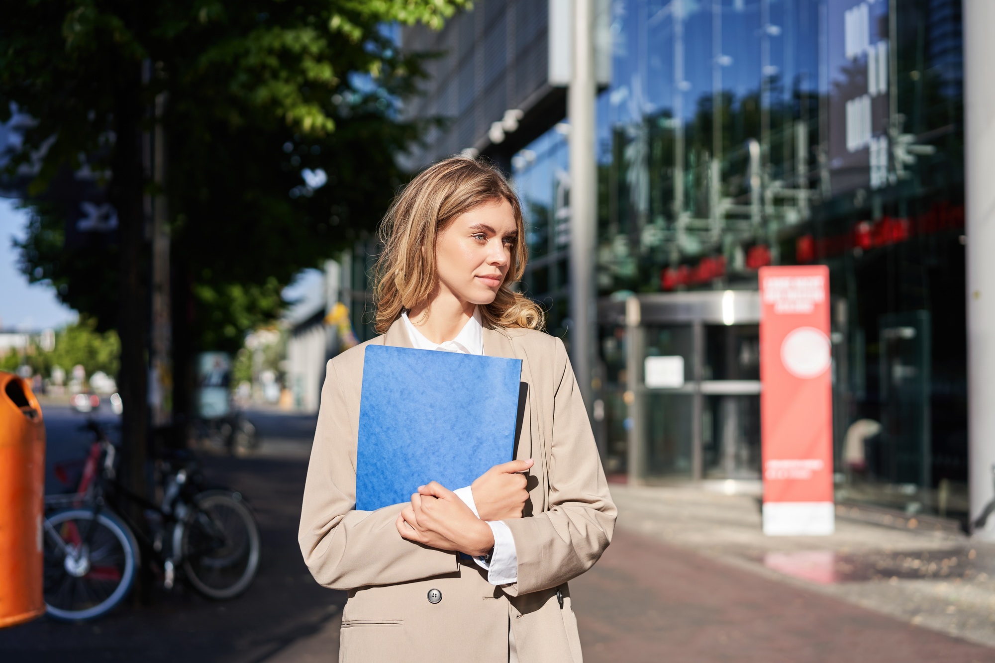 Work and corporate people. Confident businesswoman holding a blue folder with business documents