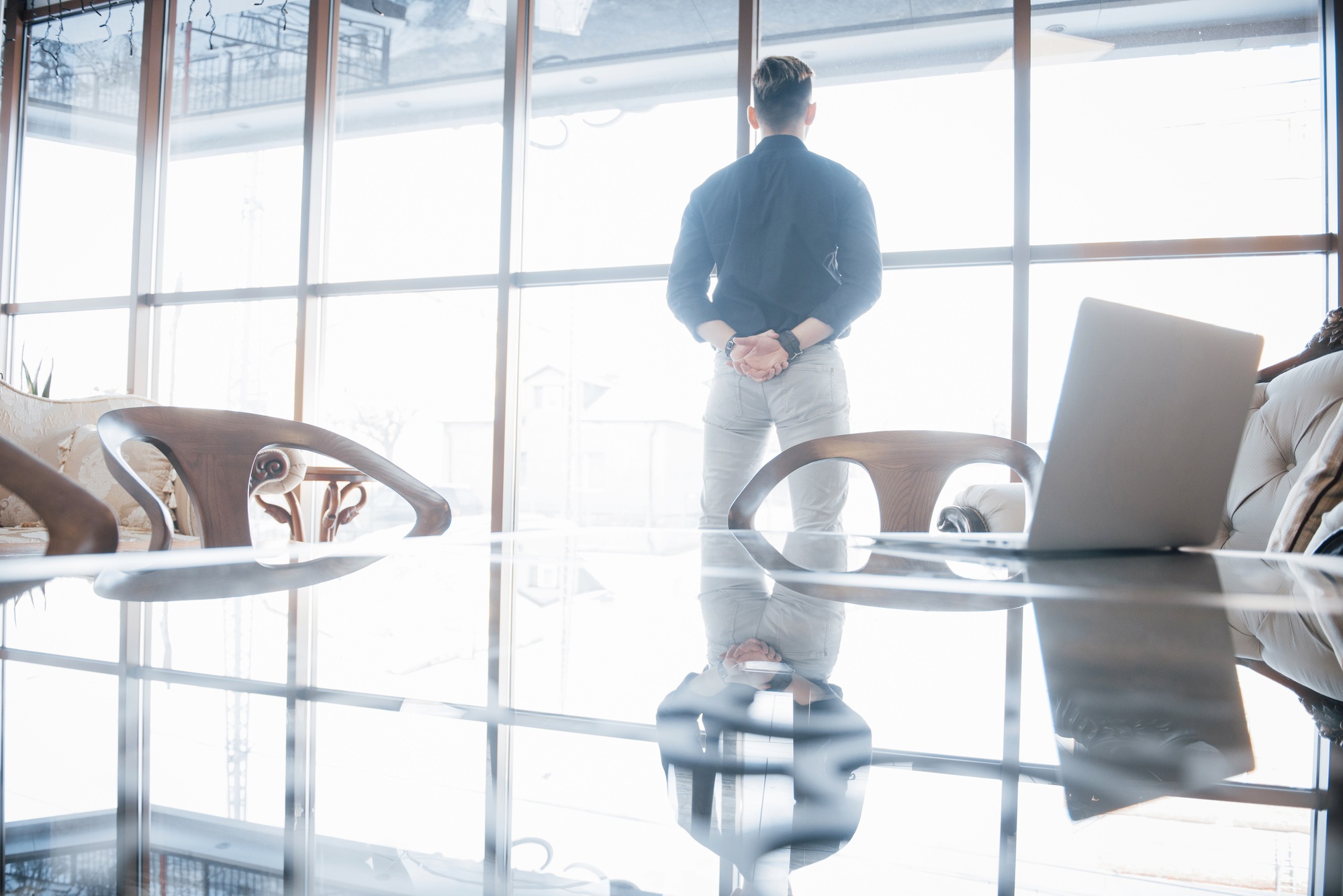 Young business executive and leader standing confidently in the the top floor office