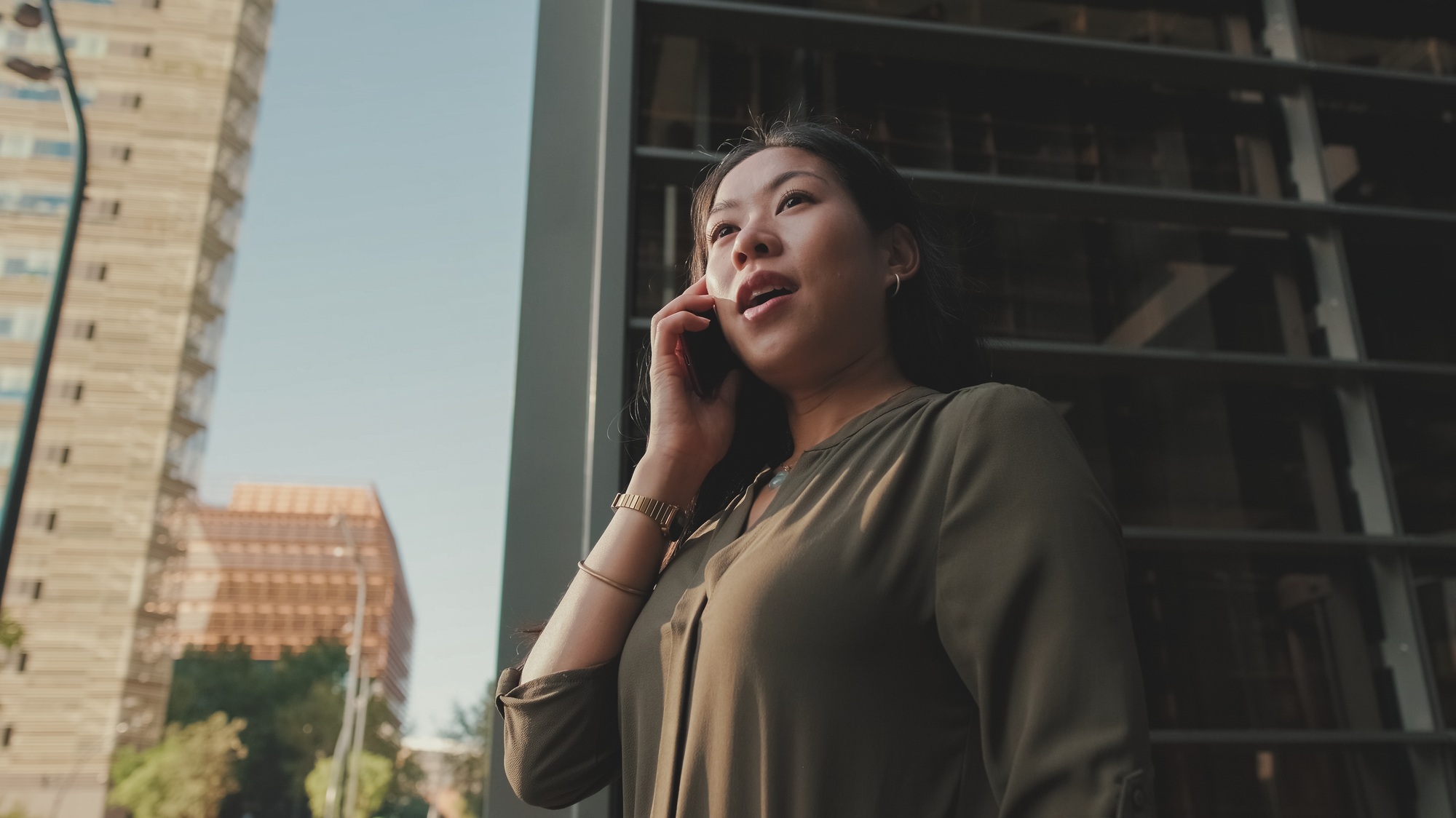 Young businesswoman talking on smartphone on business center background