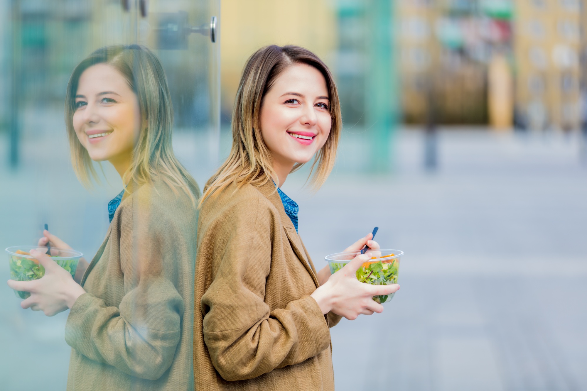 Young businesswoman with salad at urban city outdoor.