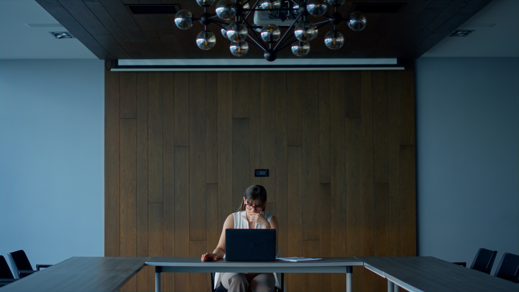 Young employee working laptop in modern interior. Focused businesswoman thinking