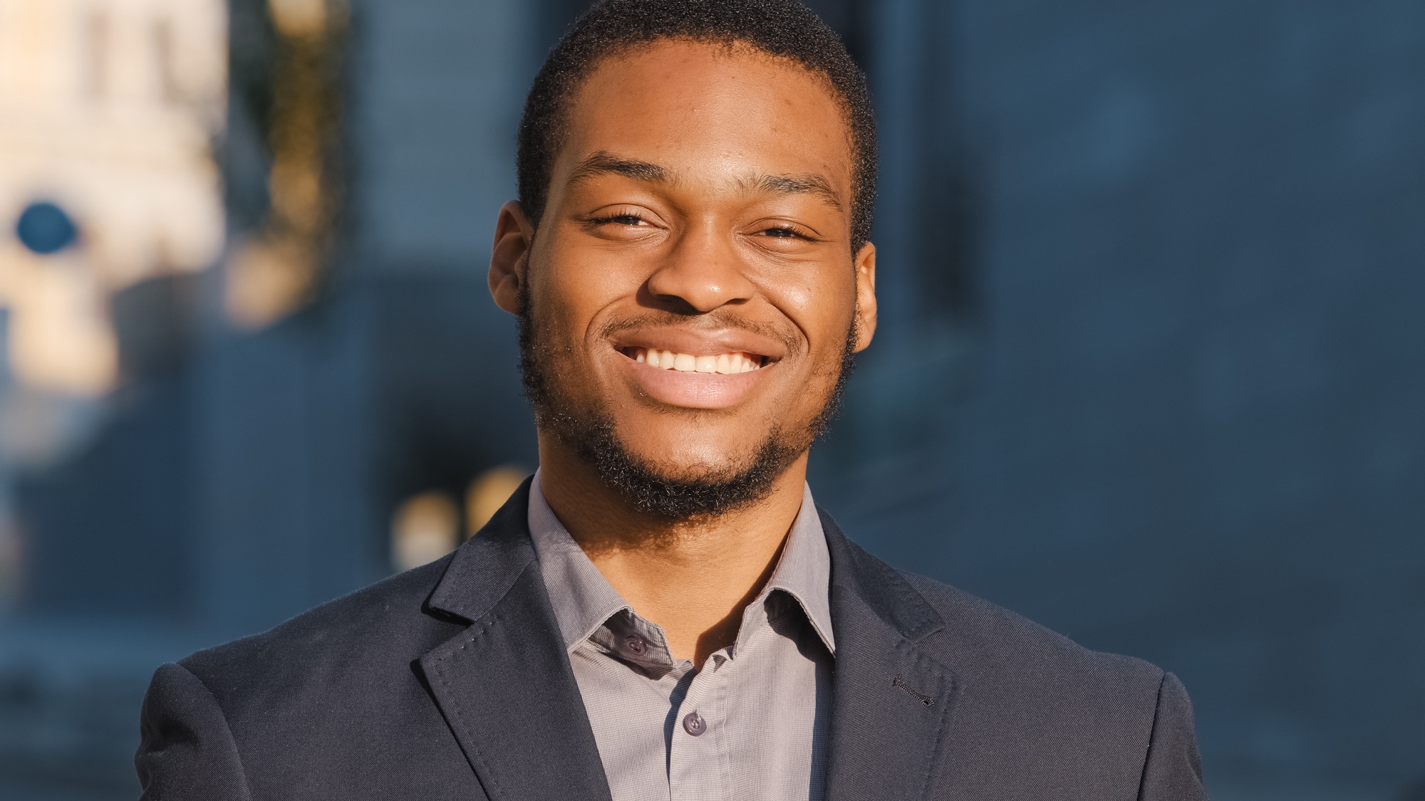 Young mixed race male office worker professional intern with happy face posing alone outdoor close