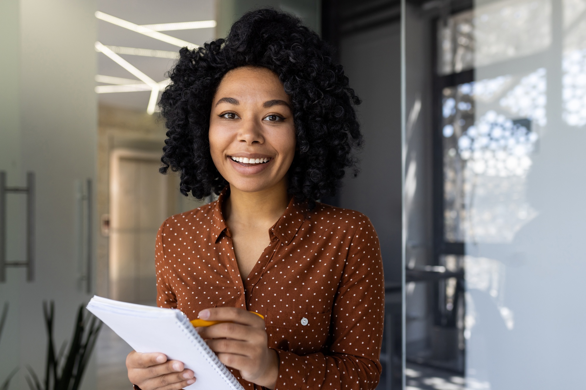 Young professional woman taking notes during an online training