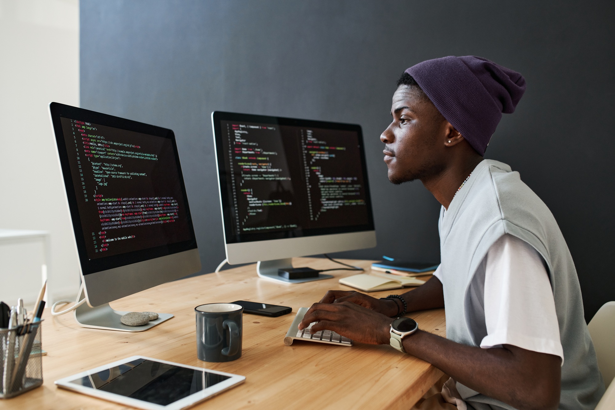 Young serious African American male programmer working over new software