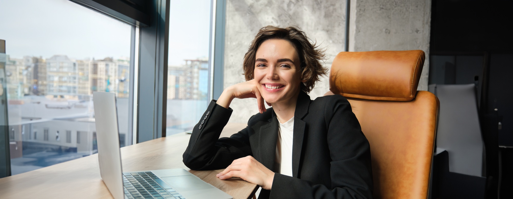 Young successful woman in business suit, sitting in her office corporation, lady boss working on