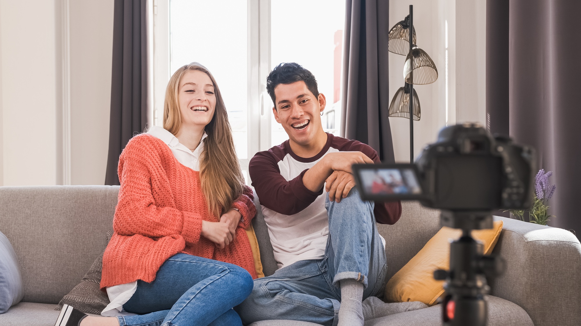Young video bloggers having fun together and creating content while making a video at home