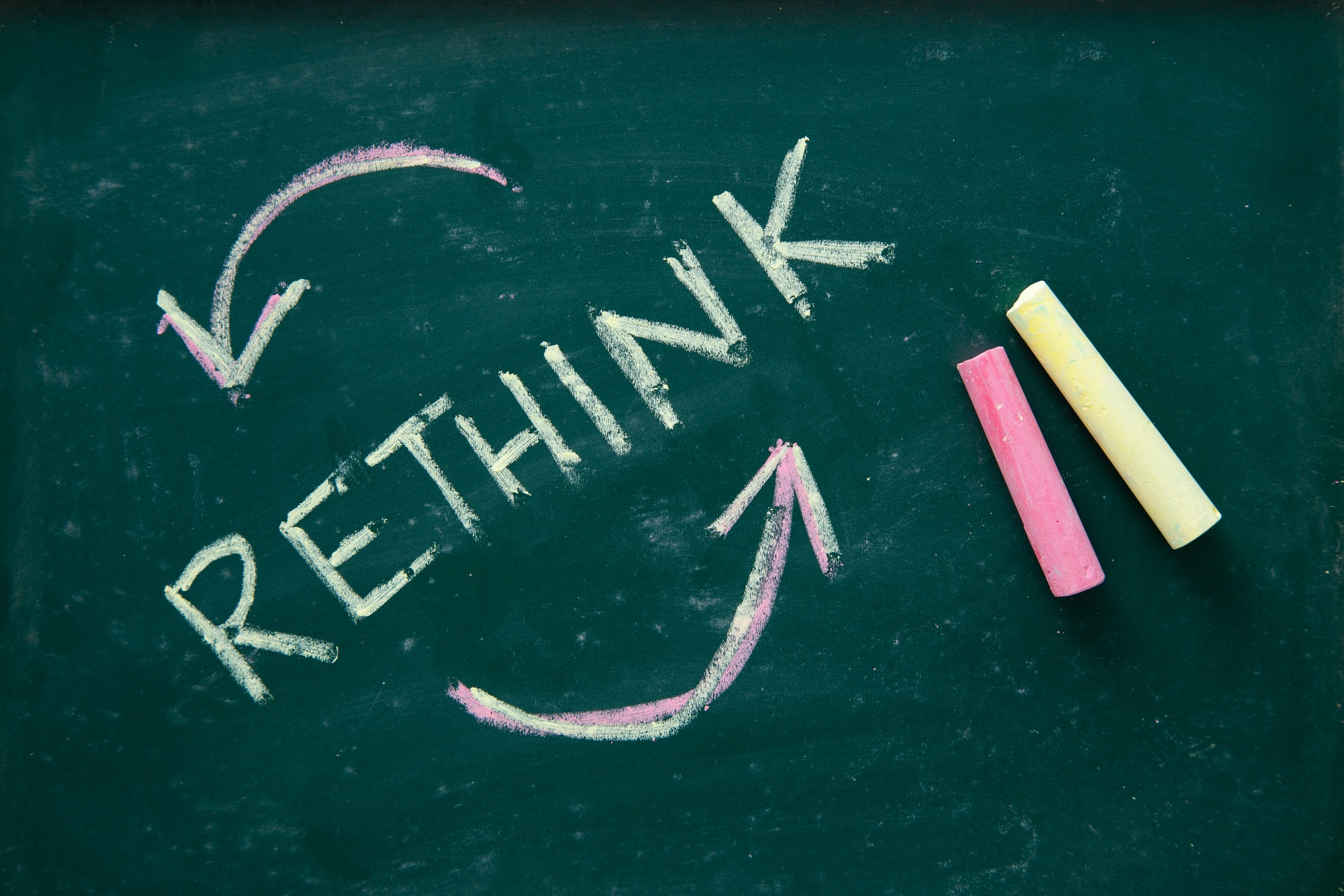Hand writing Rethink on blackboard.