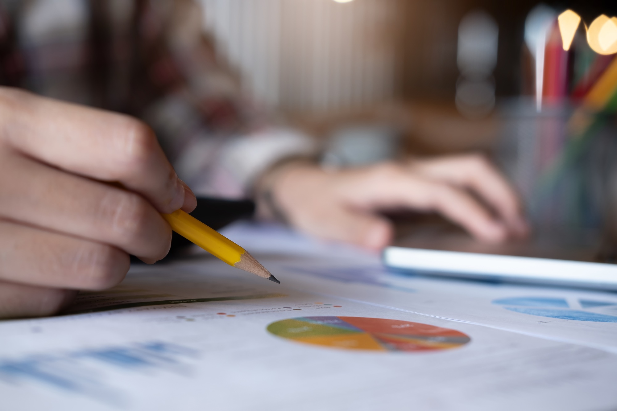 Woman holding pen using calculator with analyze graph chart and computer laptop for profit forecast