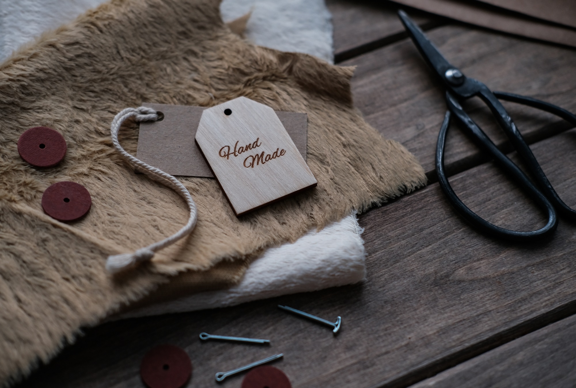 A layout with sewing accessories and a tag with the text Handmade. Hobby, small business