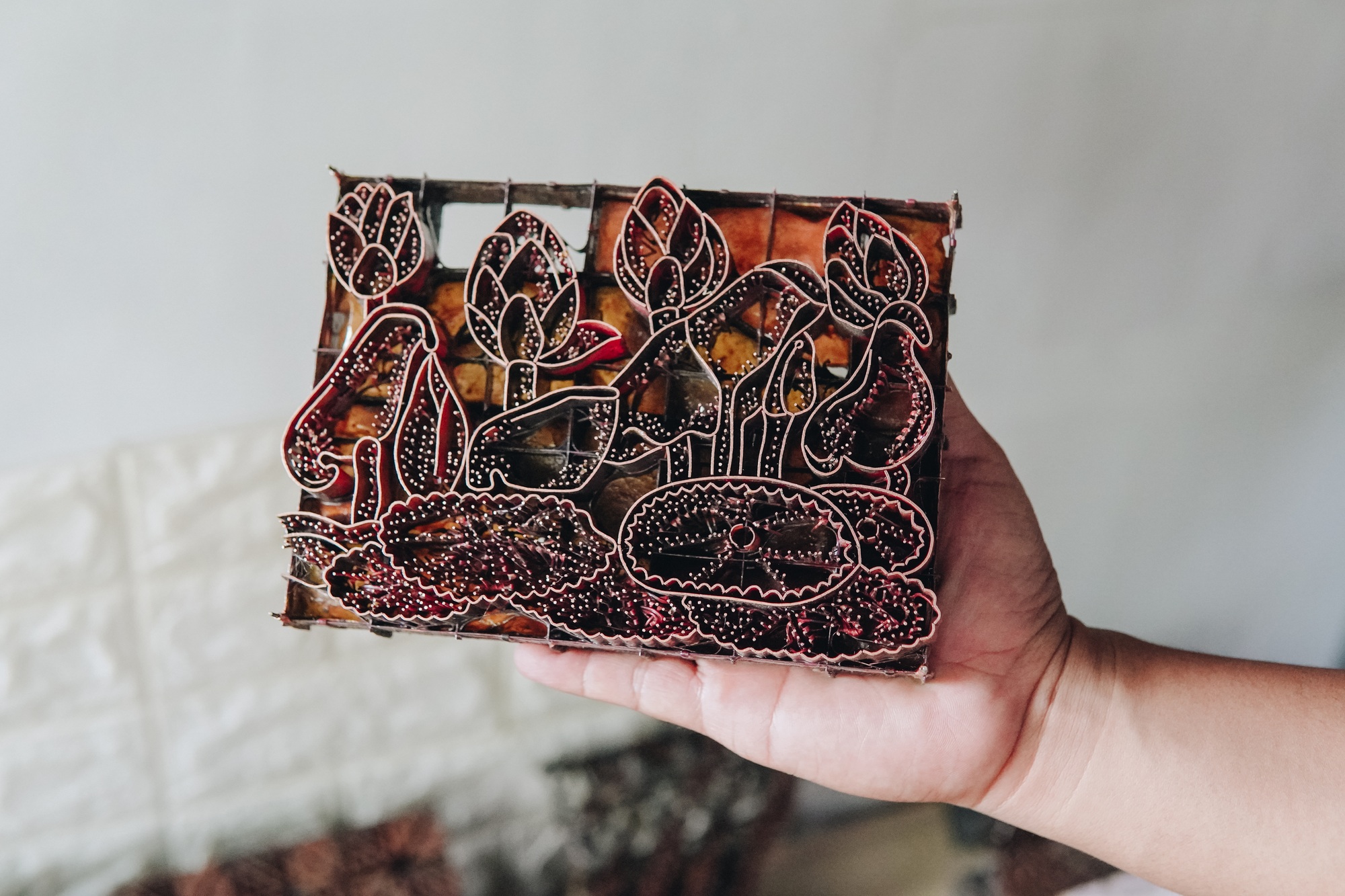 A person is holding batik handcraft product with different colored handmade craft batik.