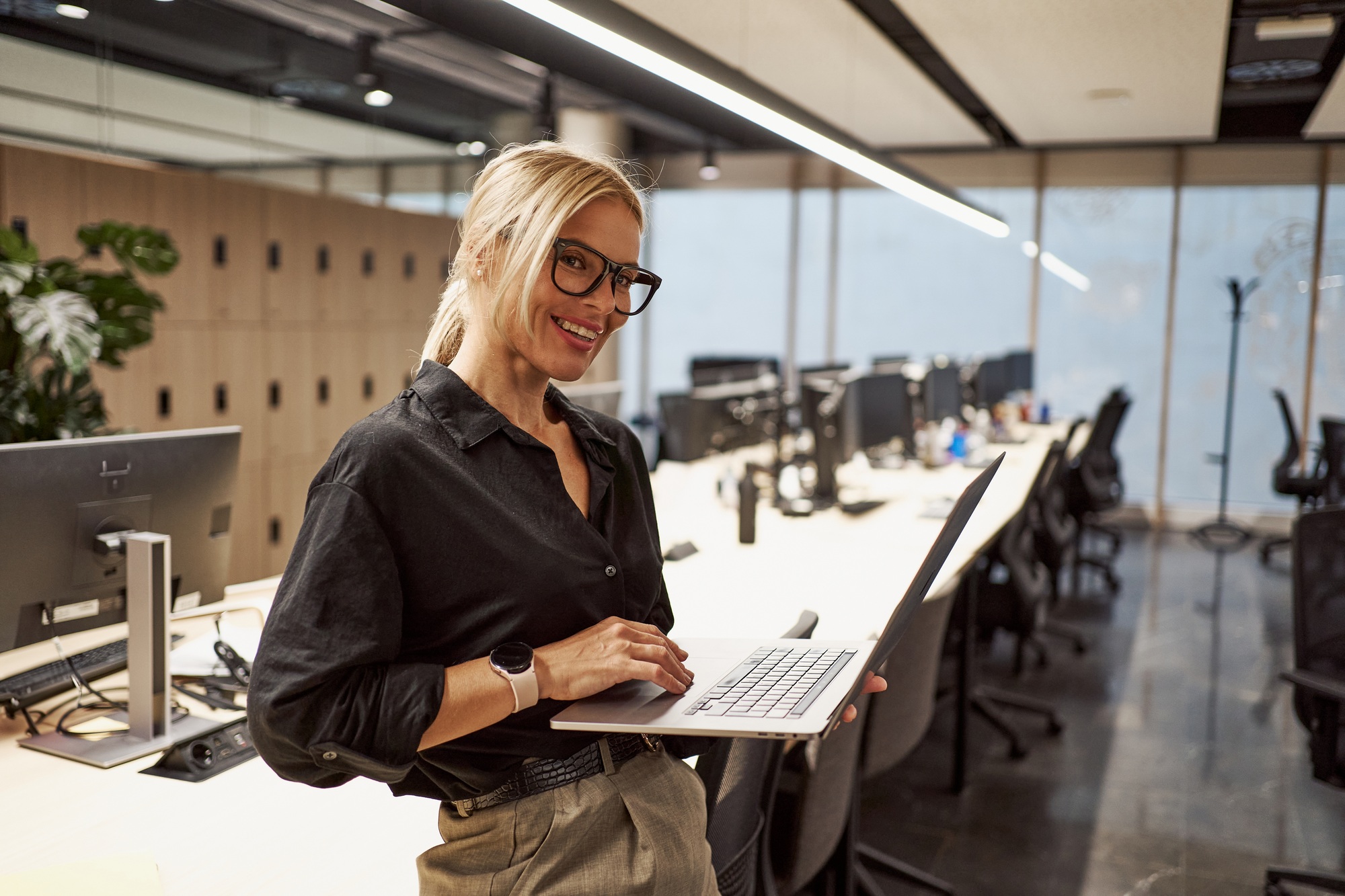 A Professional Woman Working in a Modern Office Environment Using Her Laptop Effectively