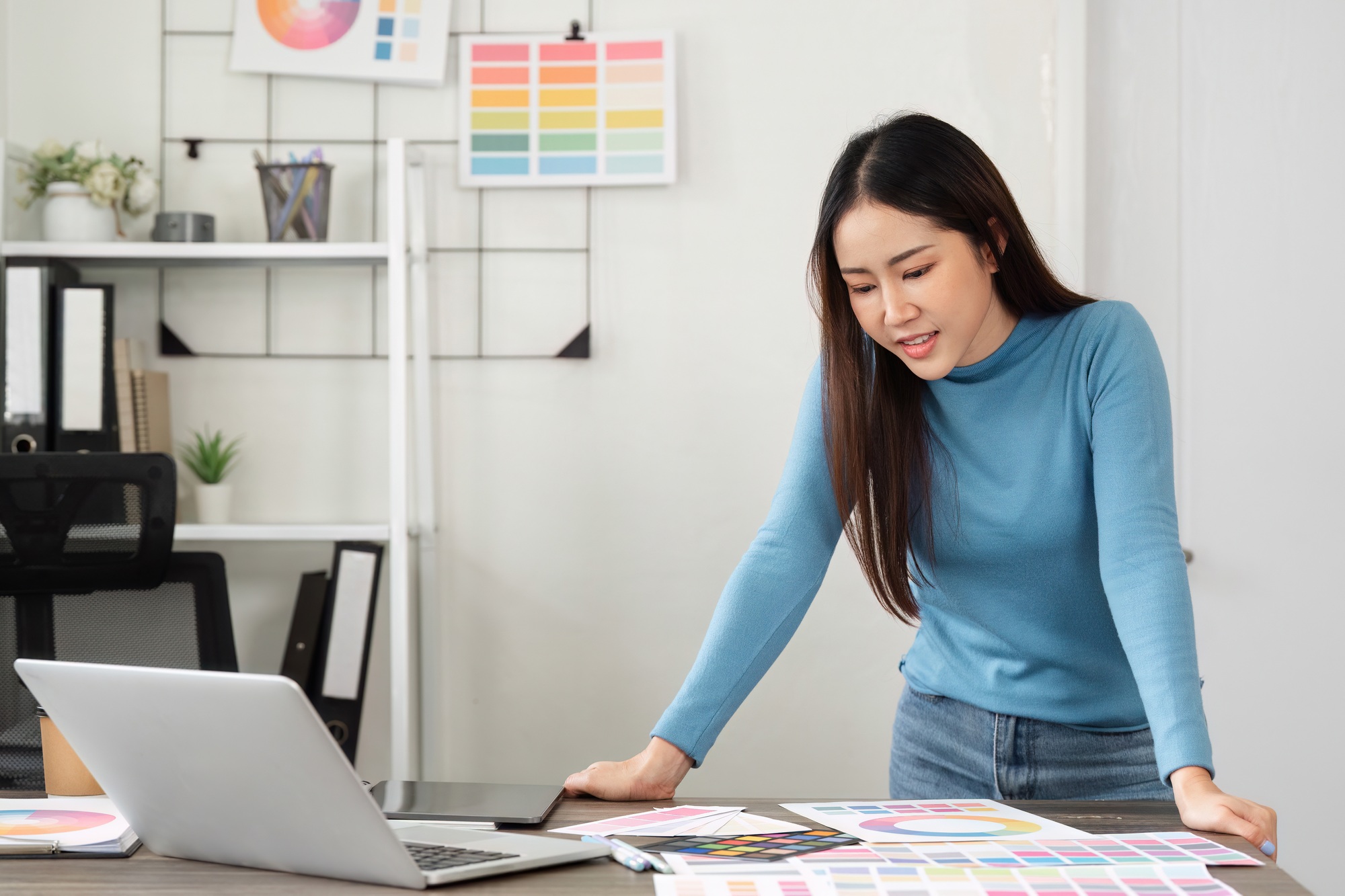 A woman engaged in the creative design process, exploring color palettes and ideas