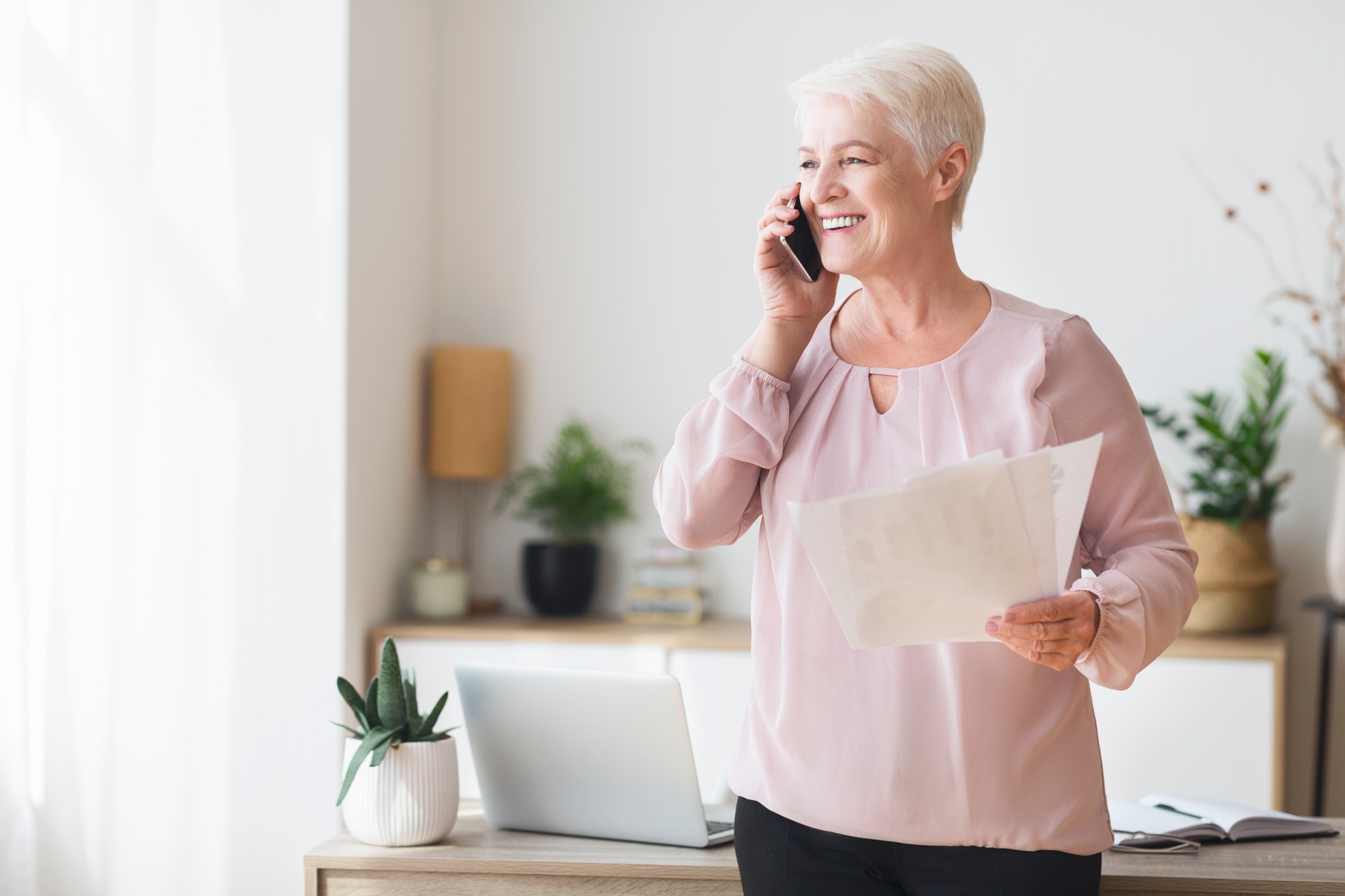 Aged business consultant talking by phone with clients