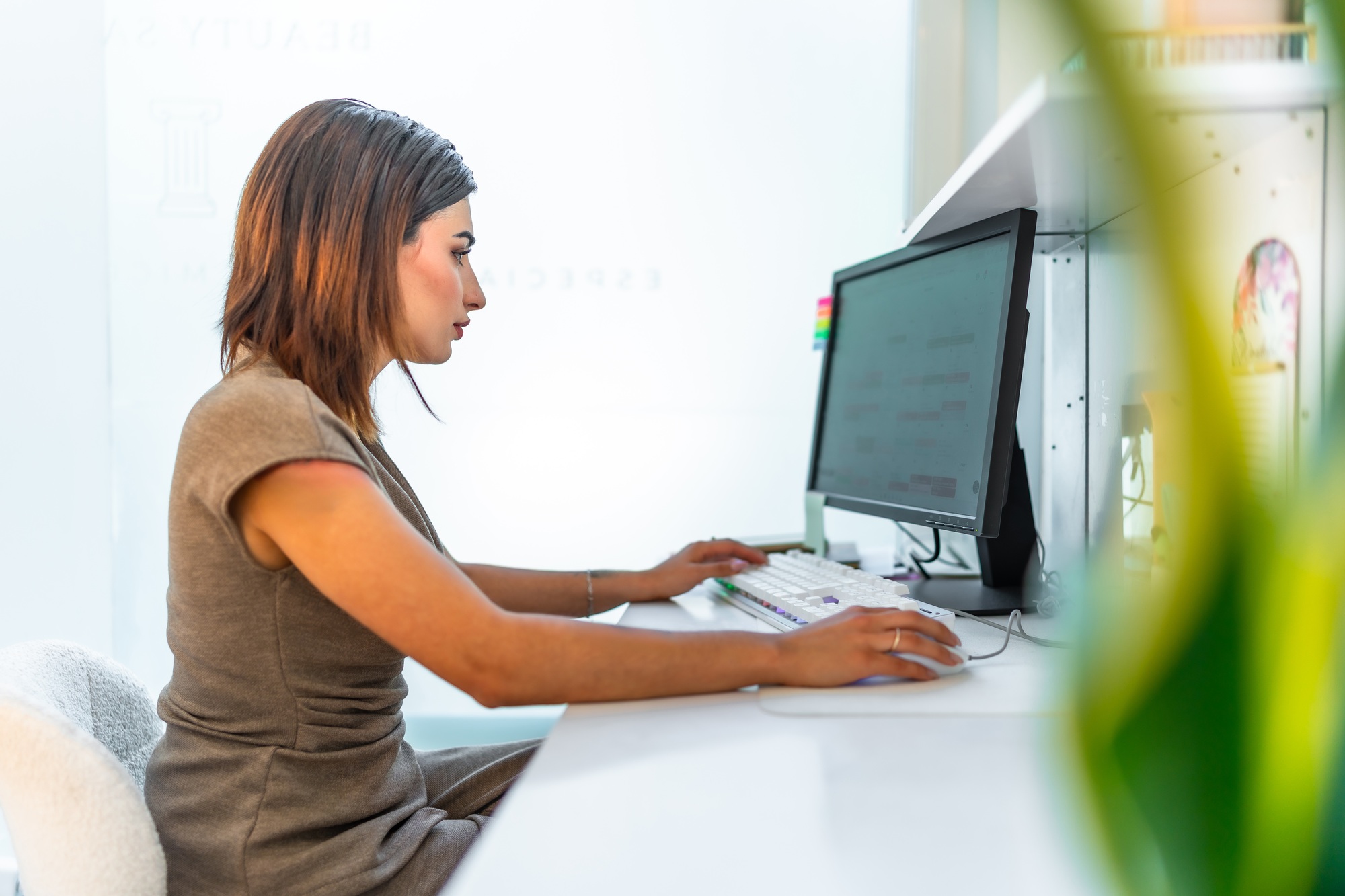 Beautician managing appointments using computer software in beauty salon