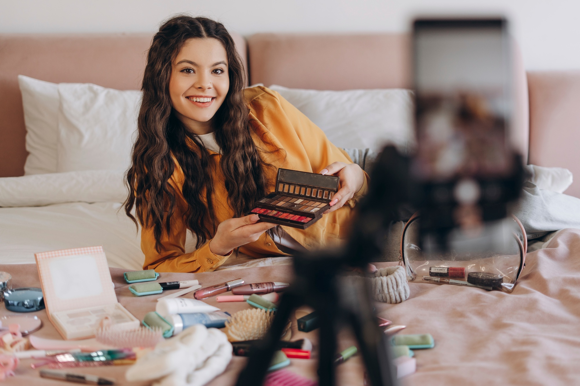 Beautiful young teenager testing beauty product and smiling while making social media video