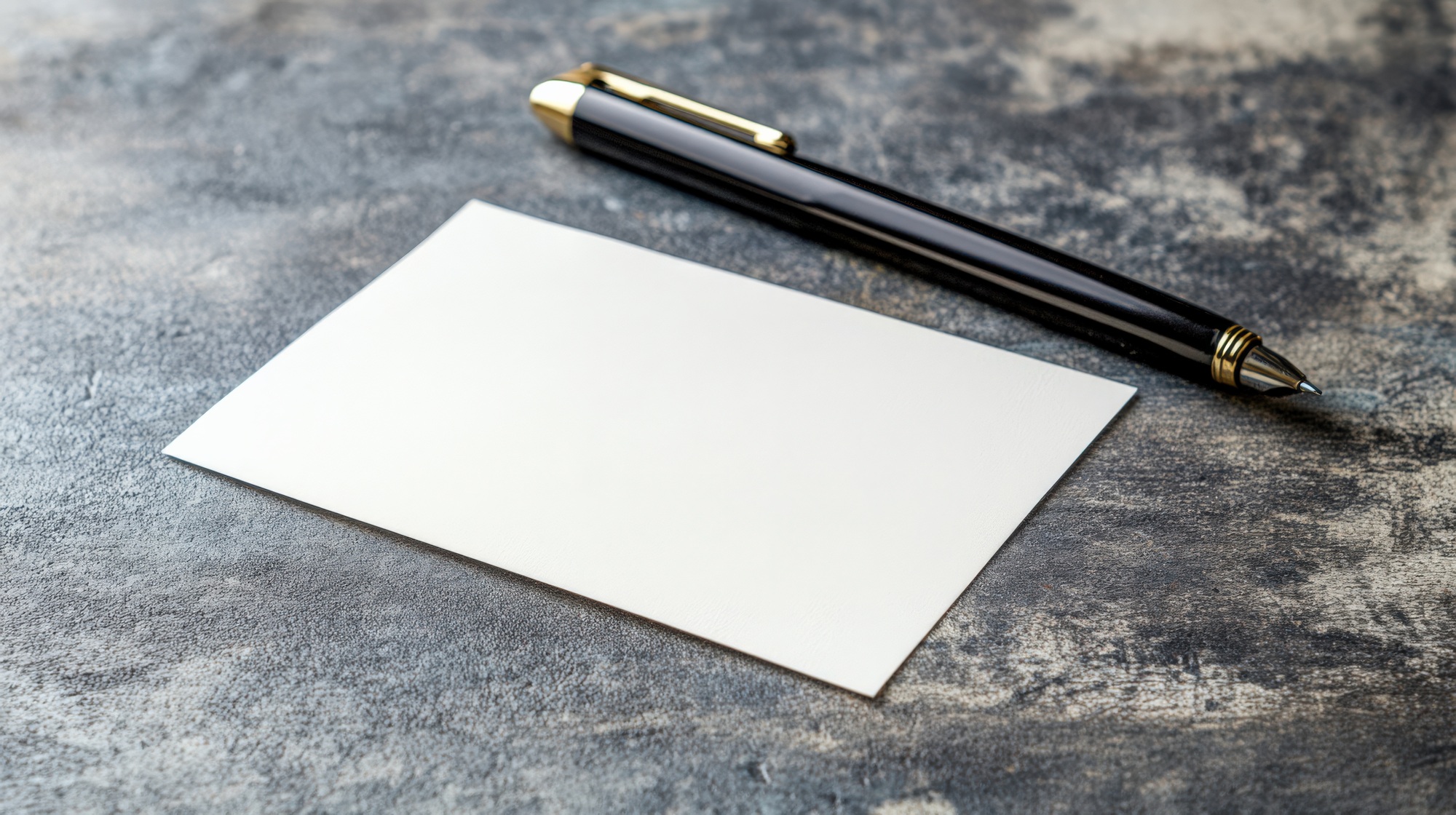 Blank business card with a pen on a textured surface for branding and networking.