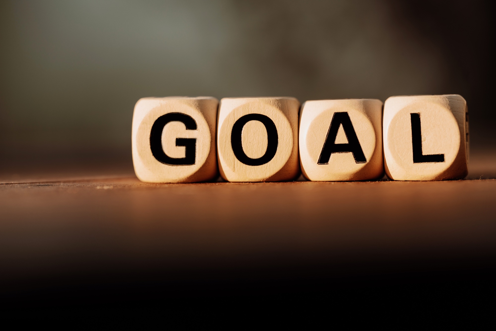 Block wood with GOAL on abstract blurred backgroune. Business goal word concept.