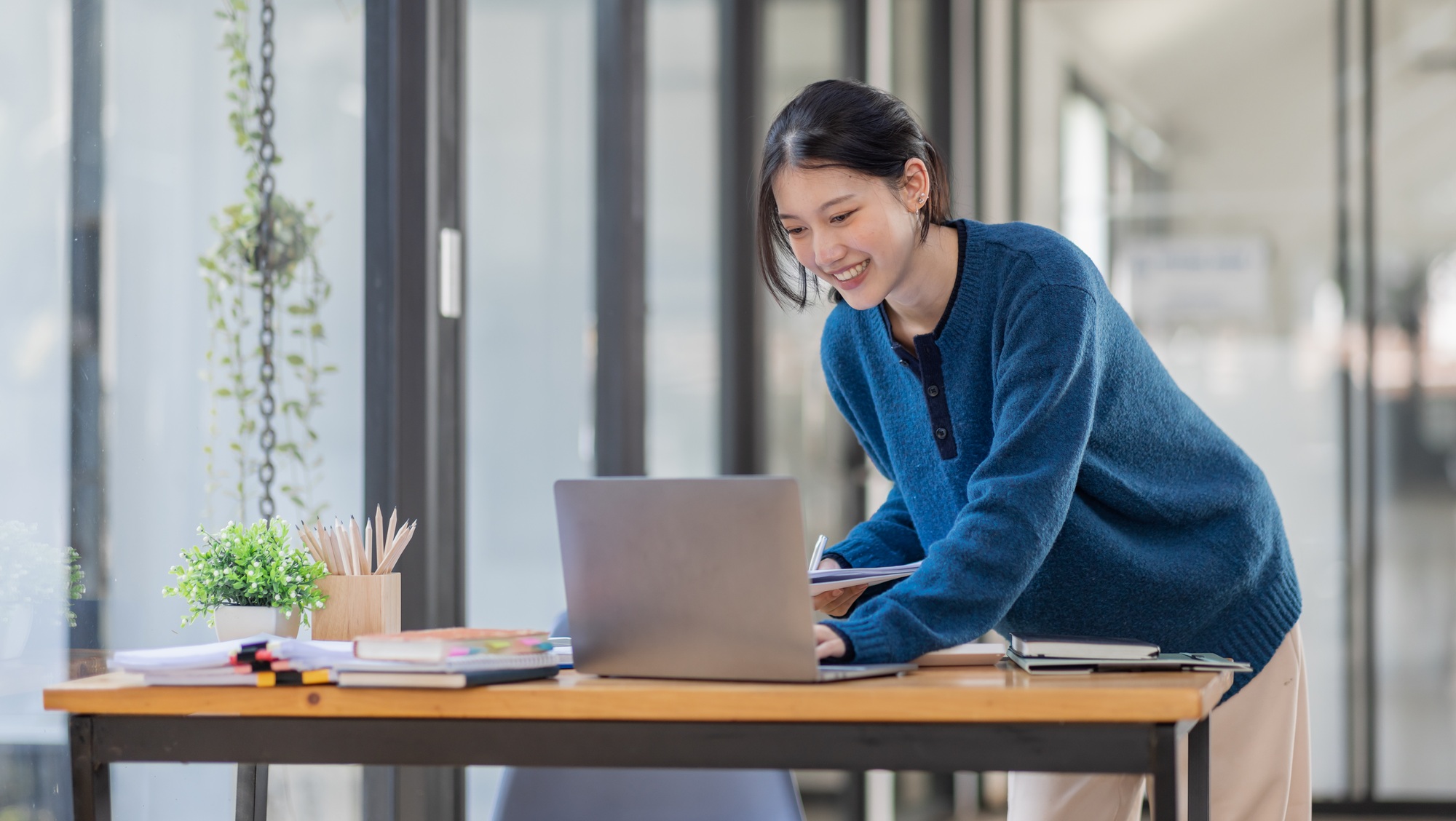 Business Asian woman Using laptop computer and working at office with calculator document on desk,