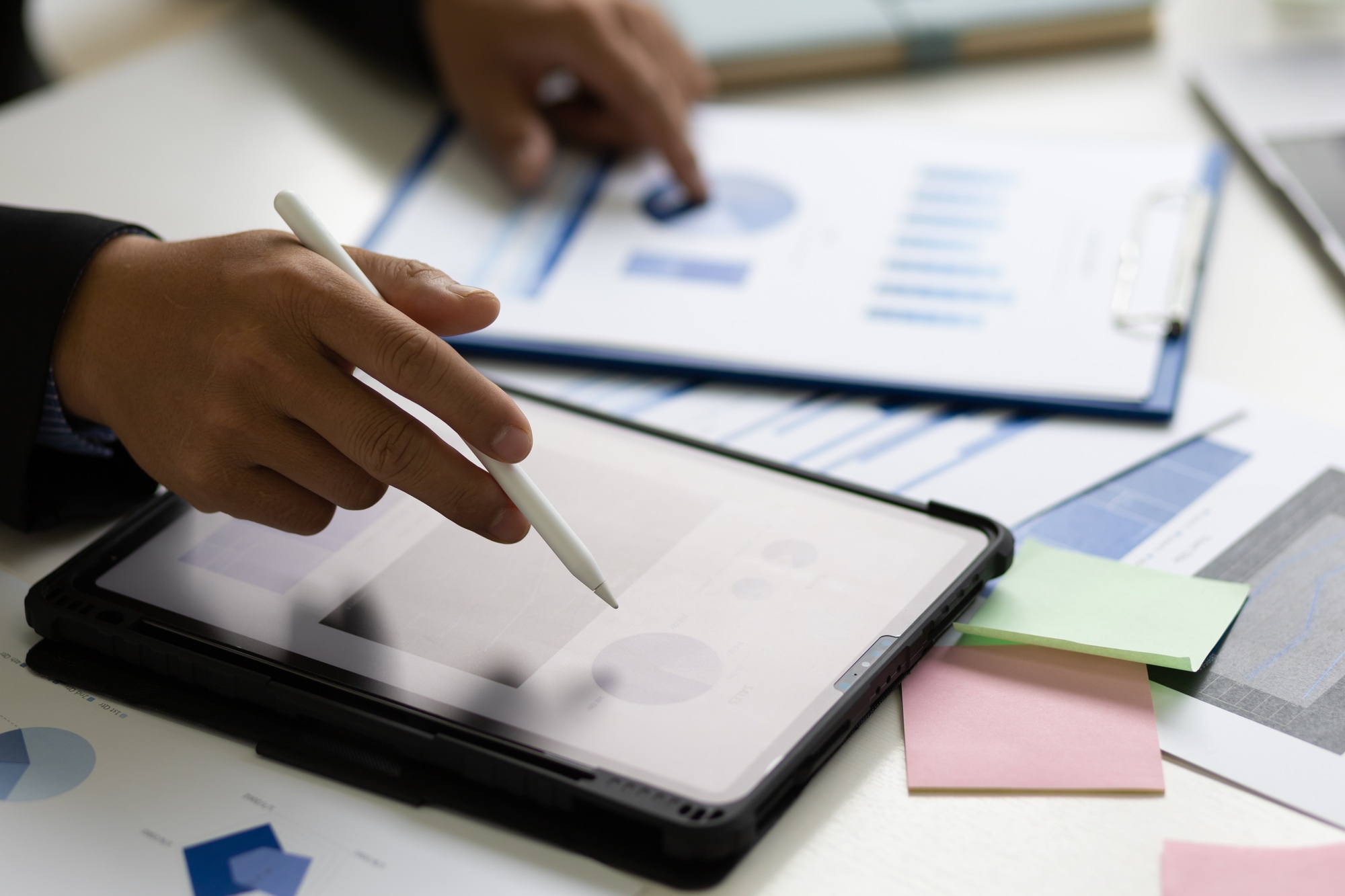 Businessman analyzes company marketing growth data and makes investment plans on tablet.
