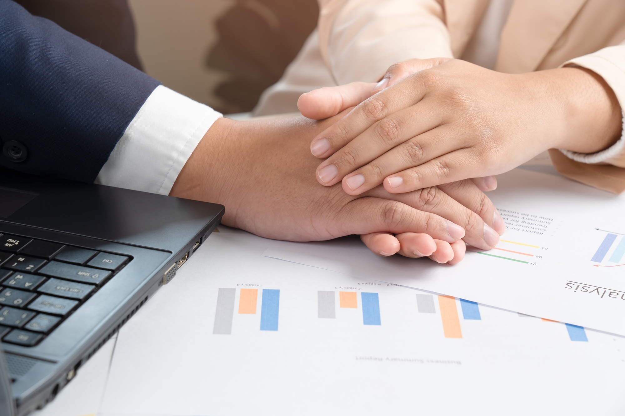 Businessman and woman join hands support each other for doing business sales report