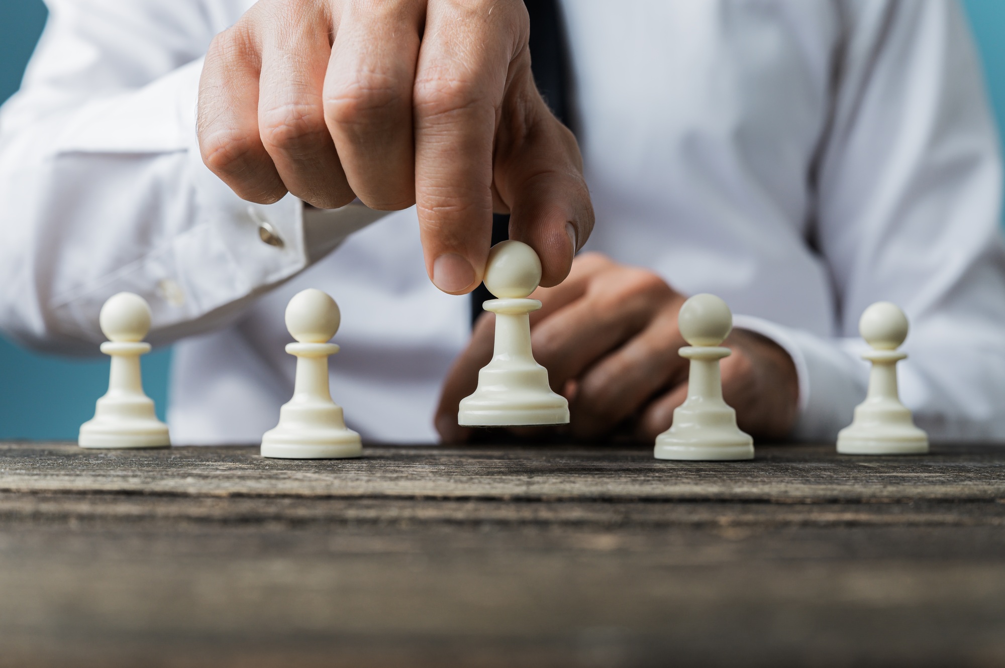 Businessman positioning white pawn chess piece in front of the o
