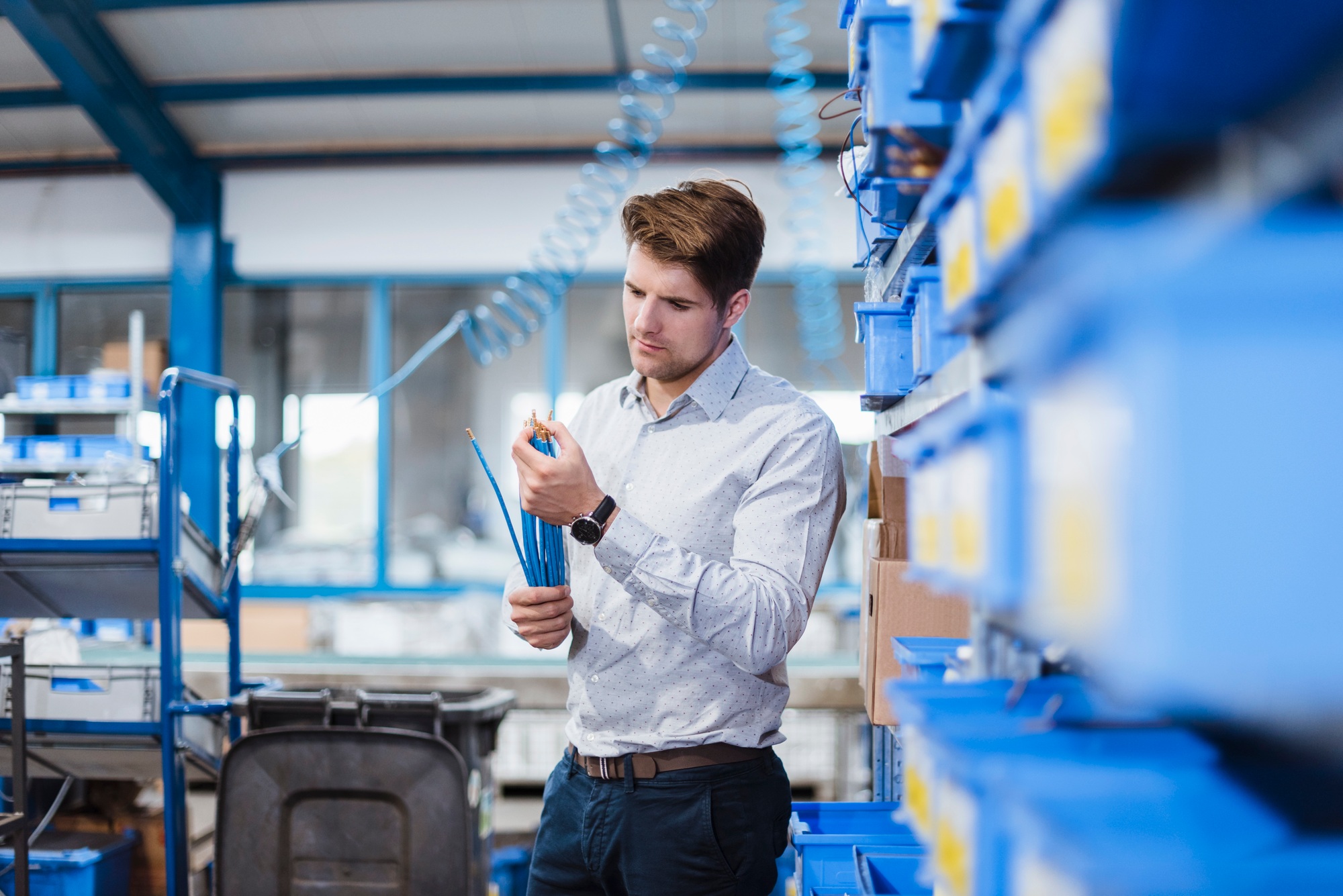 Businessman standing in shop floor, testing products