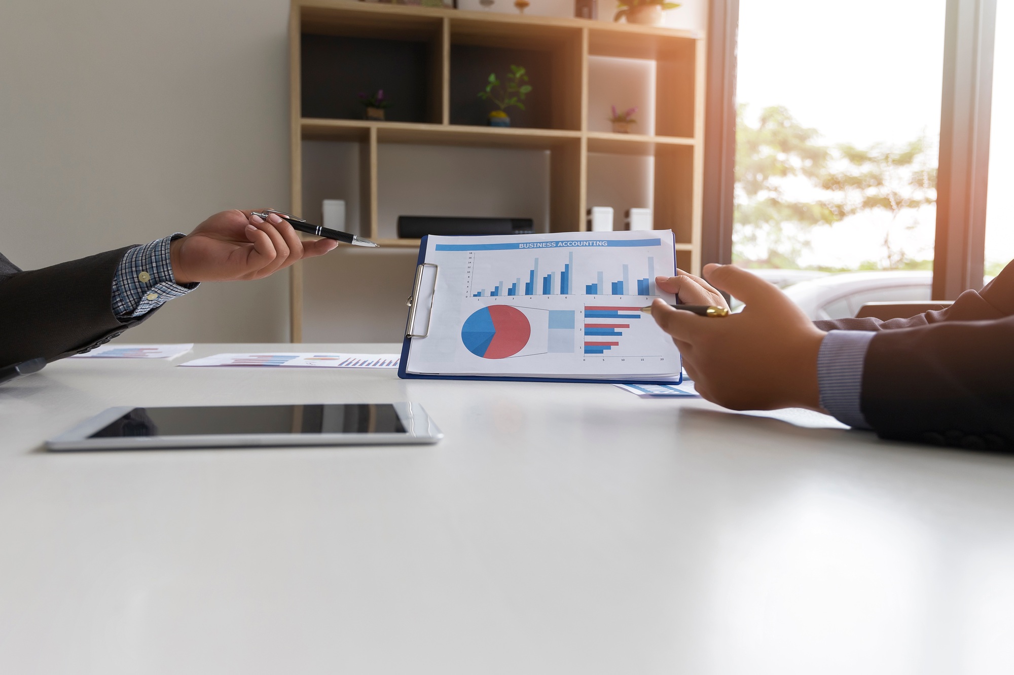 Businessmen present earnings report , the monthly college budget, financial chart.